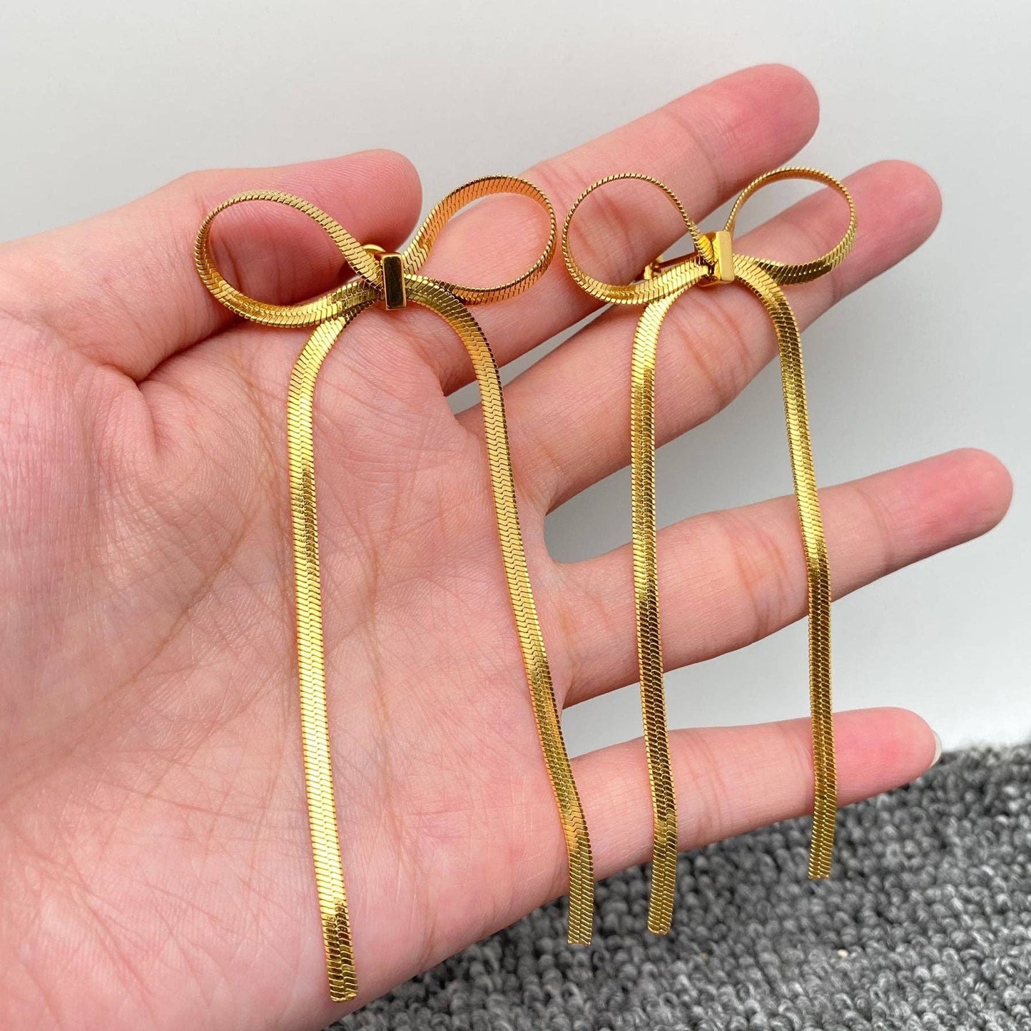 Mio Queena Chain Bow Earrings with delicate chain and bow design, stylish dangle earrings for women