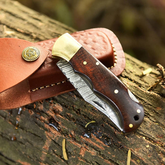 Handmade Damascus folding knife with intricate pattern, featuring a sleek metal blade and ergonomic handle by Liconte LLC.