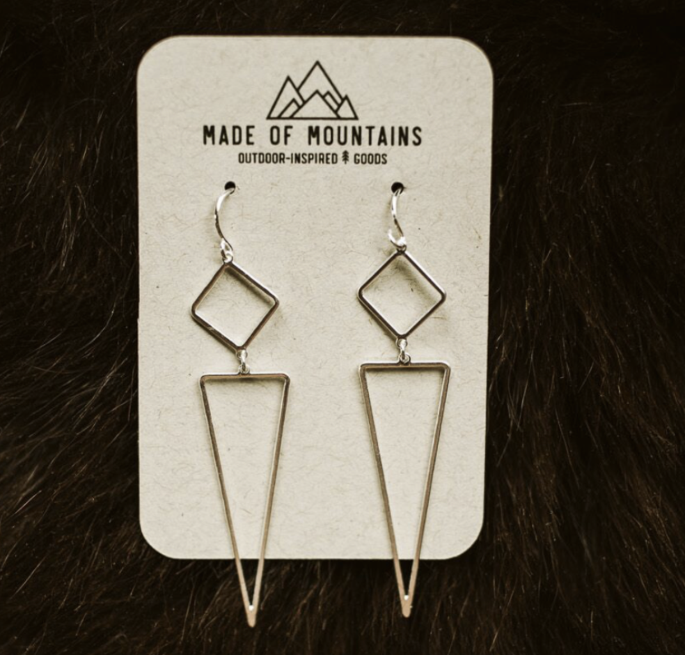 Made of Mountains Geo Dangle Earrings featuring geometric metal design hanging from ear hooks.