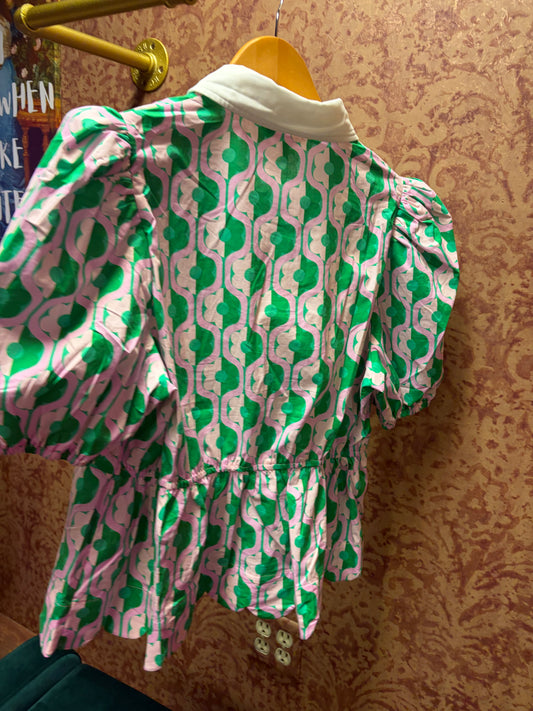 Entro Mod Floral Blouse featuring vibrant floral print and lightweight fabric, displayed on a hanger against a neutral background.