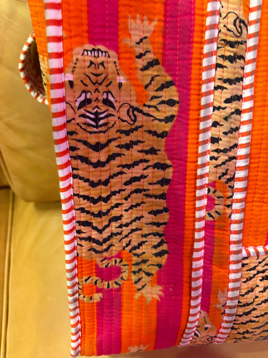 Pink and orange tiger print tote bag from The Roots, featuring a spacious design with sturdy handles and vibrant animal pattern.
