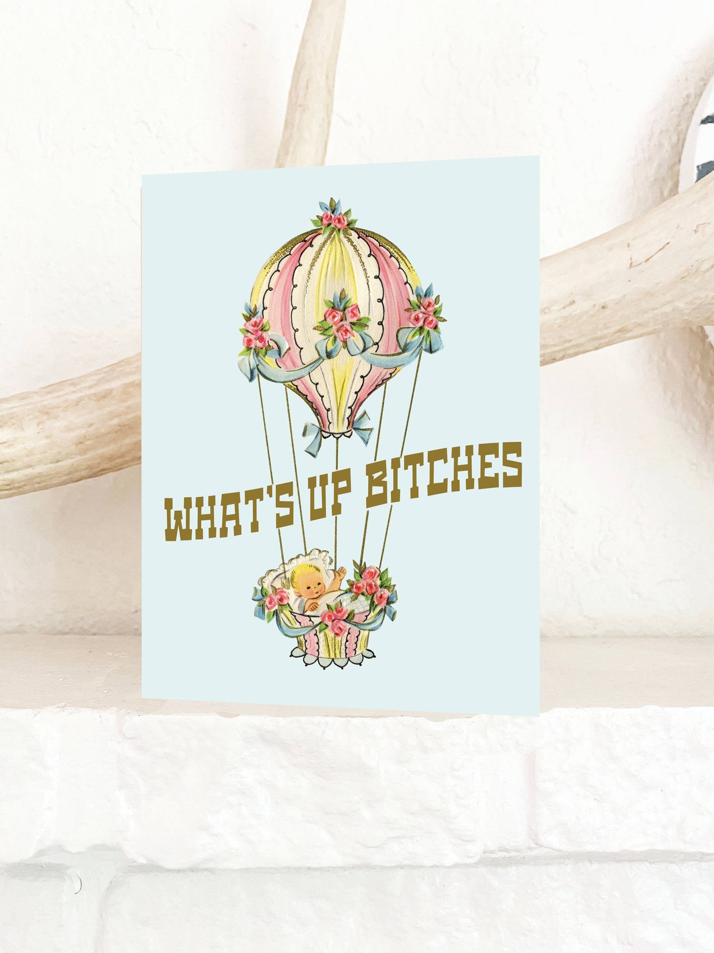 Funny baby in balloon greeting card from What's up Bitches series by The Coin Laundry, featuring retro humorous design.