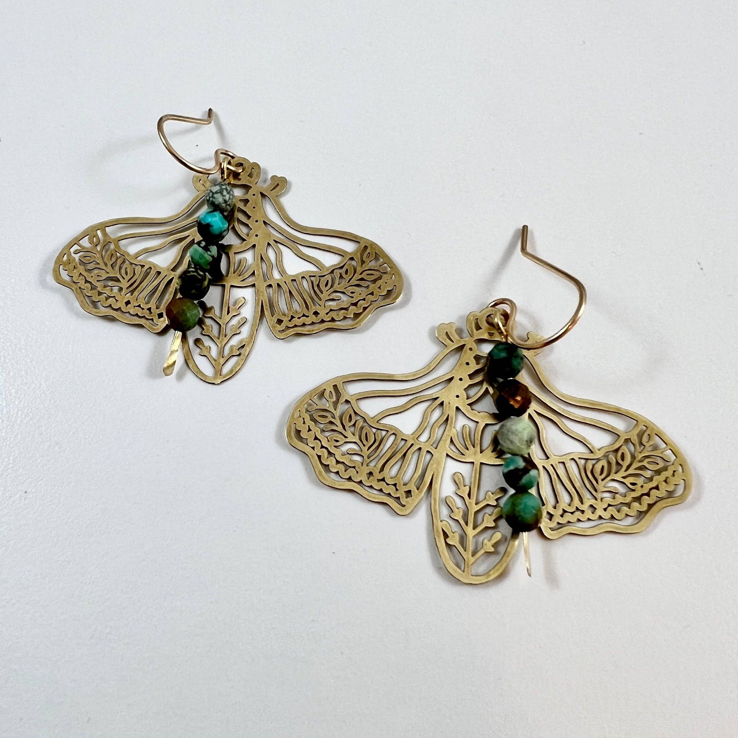 Handmade Peppered Moth earrings by Fluff Hardware featuring detailed black and white moth design on silver hooks.