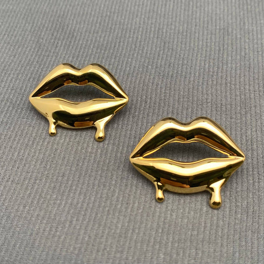 Glossy Lips earrings by Mio Queena featuring shiny, lip-shaped silver earrings with a smooth, reflective finish.