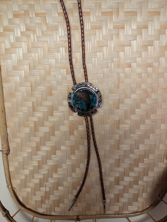 Silver BadAssBabe bolo tie featuring a detailed western-style metal clasp and black cord for a bold, stylish look.