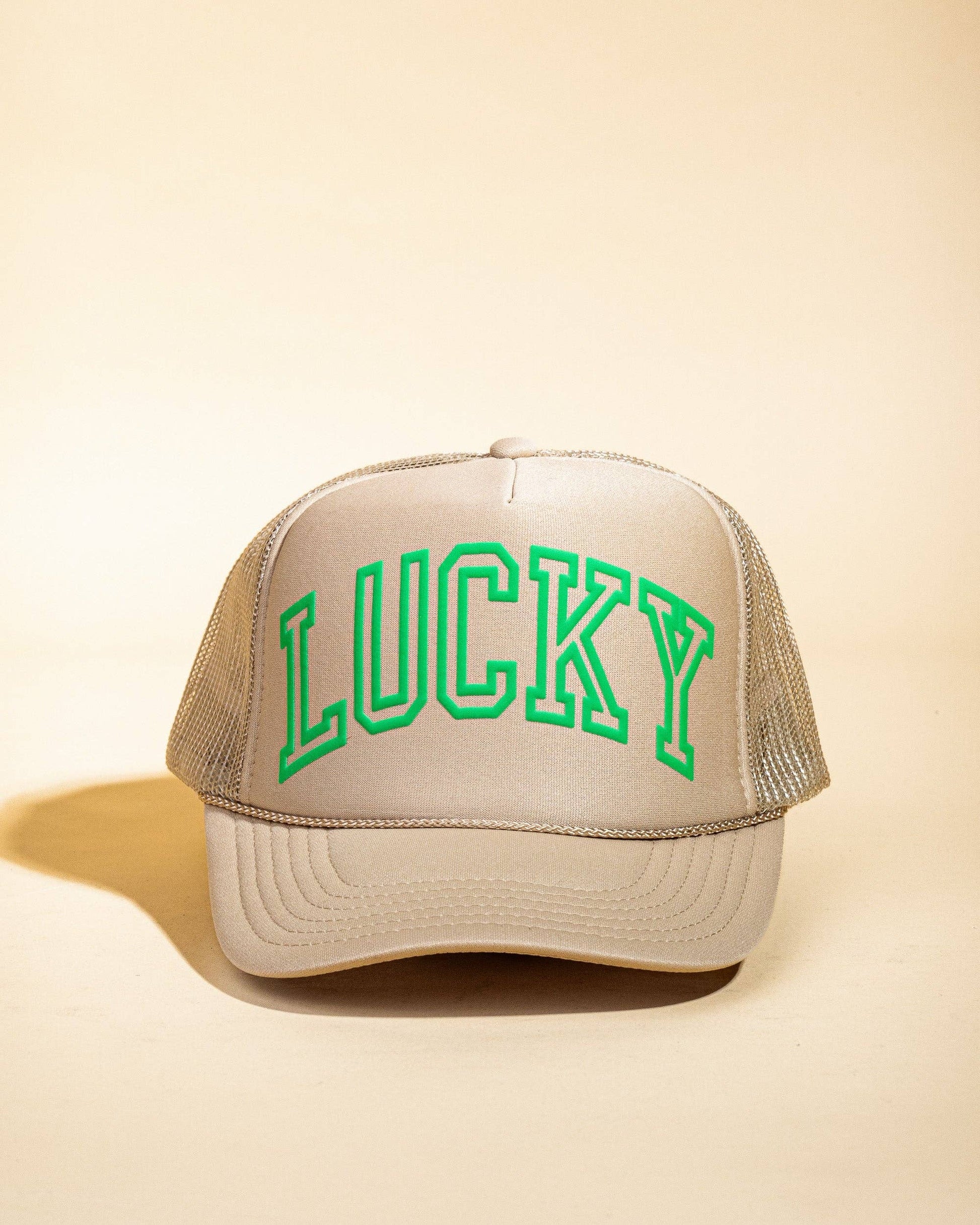 Ascot + Hart Lucky Trucker hat with adjustable strap and classic design, shown in a stylish outdoor setting.