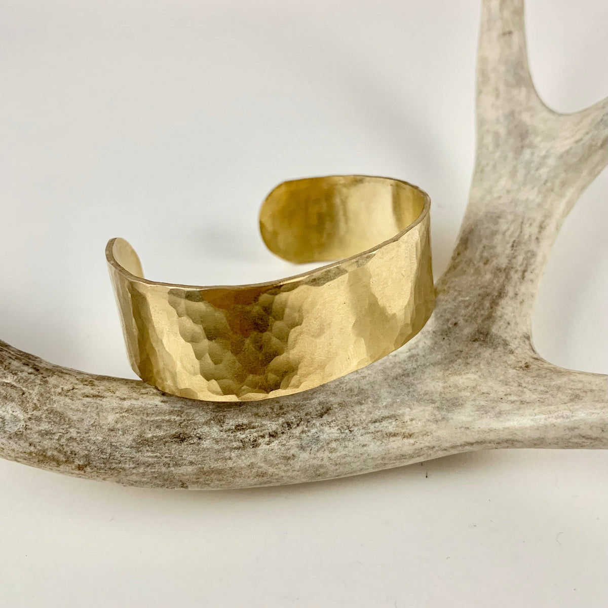Handmade She-ra style cuff bracelet by Fluff Hardware featuring bold, intricate metal designs on a wide bracelet band.