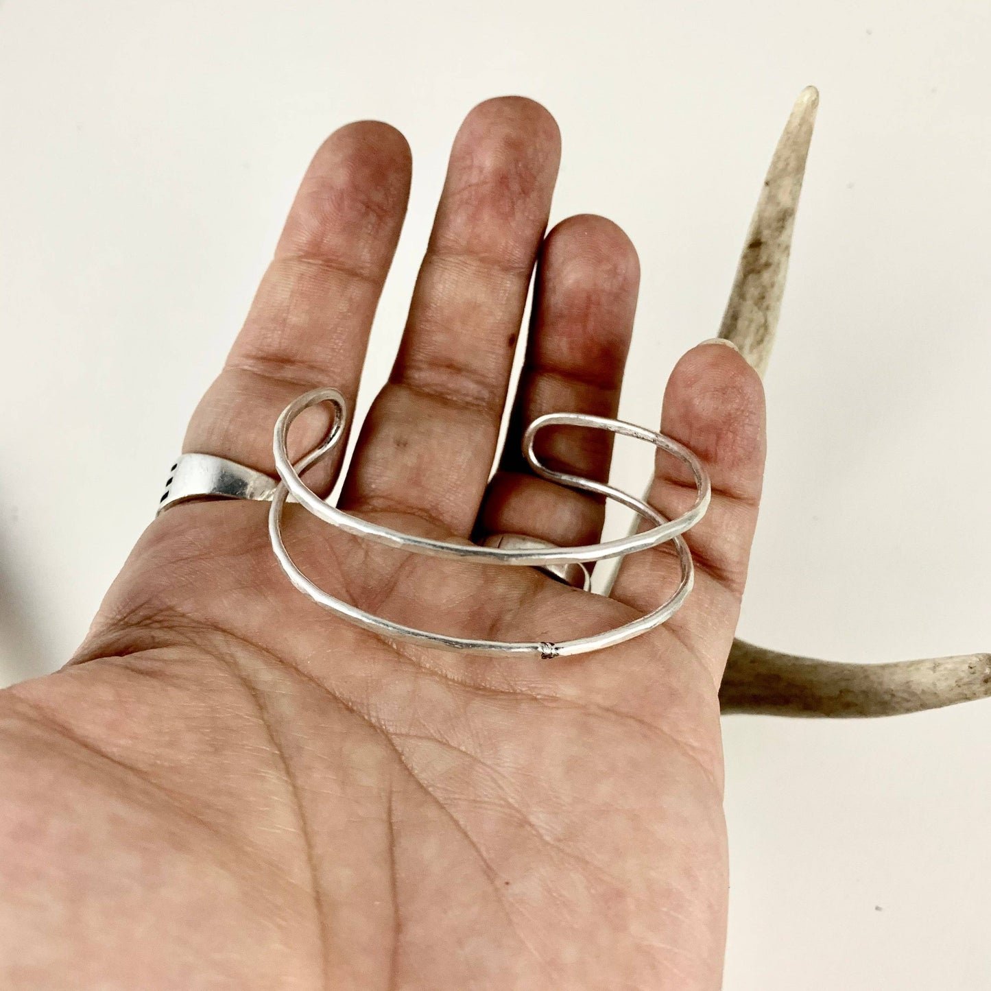 Handmade She-ra cuffs bracelet by Fluff Hardware featuring intricate metalwork and adjustable design on a neutral background.