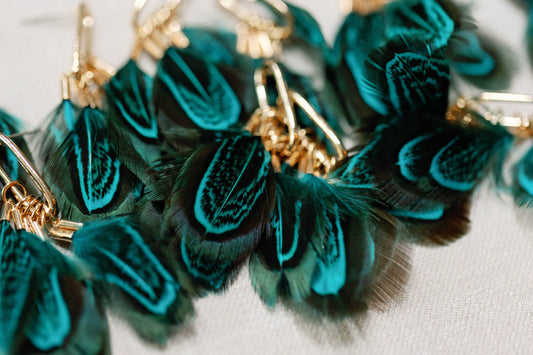 Peacock feather statement tassel earrings featuring vibrant feathers and elegant design, by St Armands Designs of Sarasota.