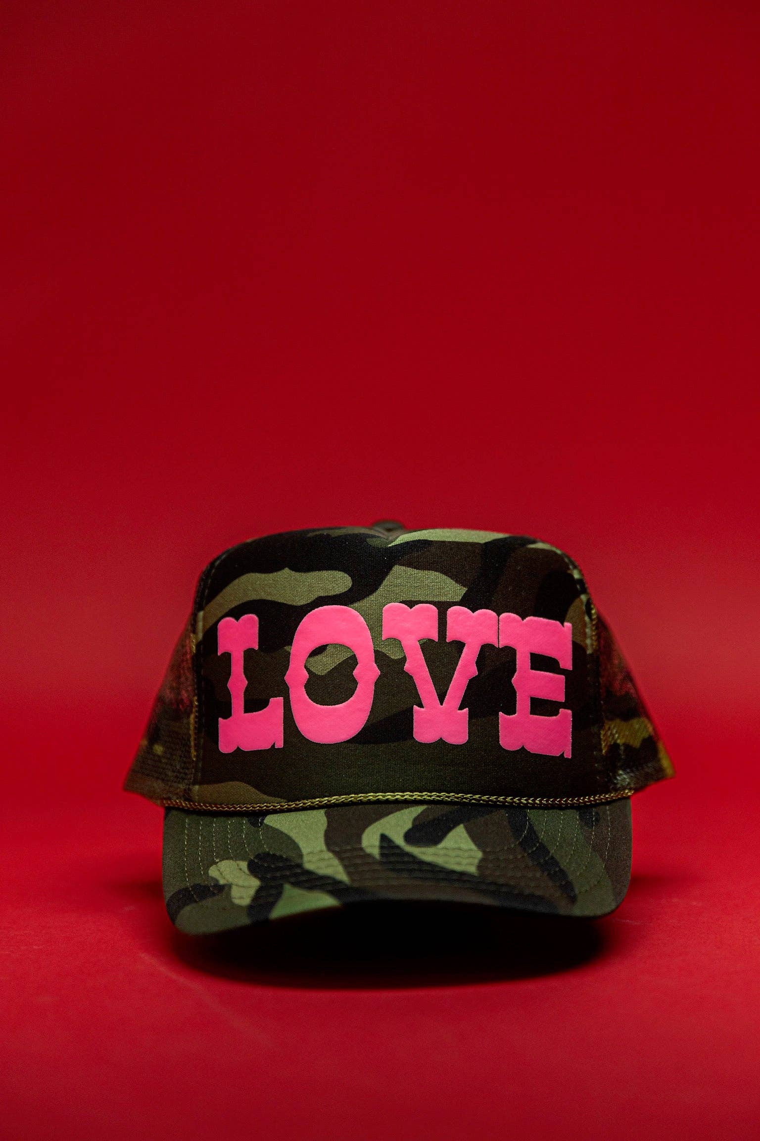 Ascot + Hart Big Love Trucker hat featuring a black cap with a bold white "Big Love" graphic and mesh back panels.