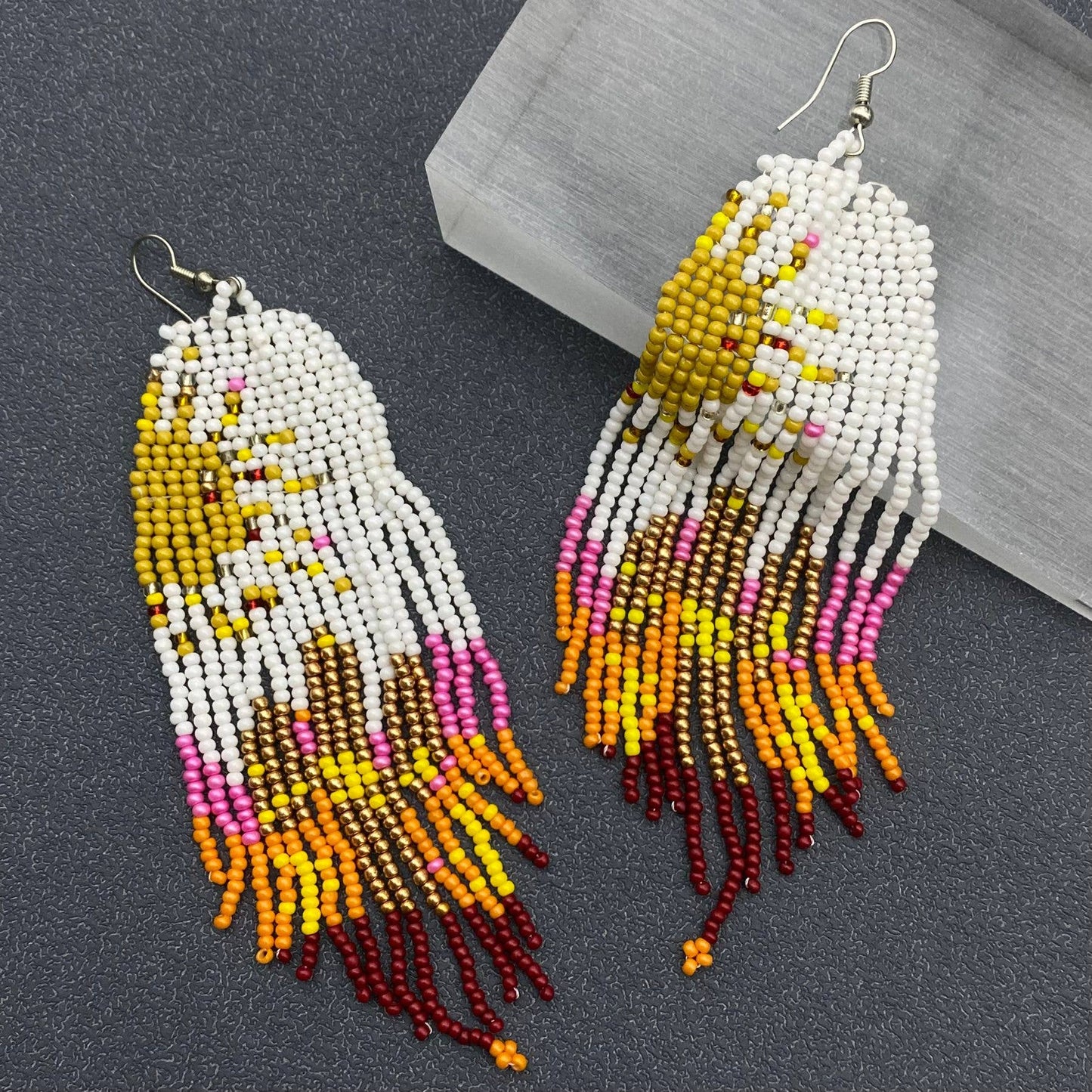 Hand-woven Sun Fringe Earrings by Mio Queena featuring intricate sun-shaped design and delicate fringe details.