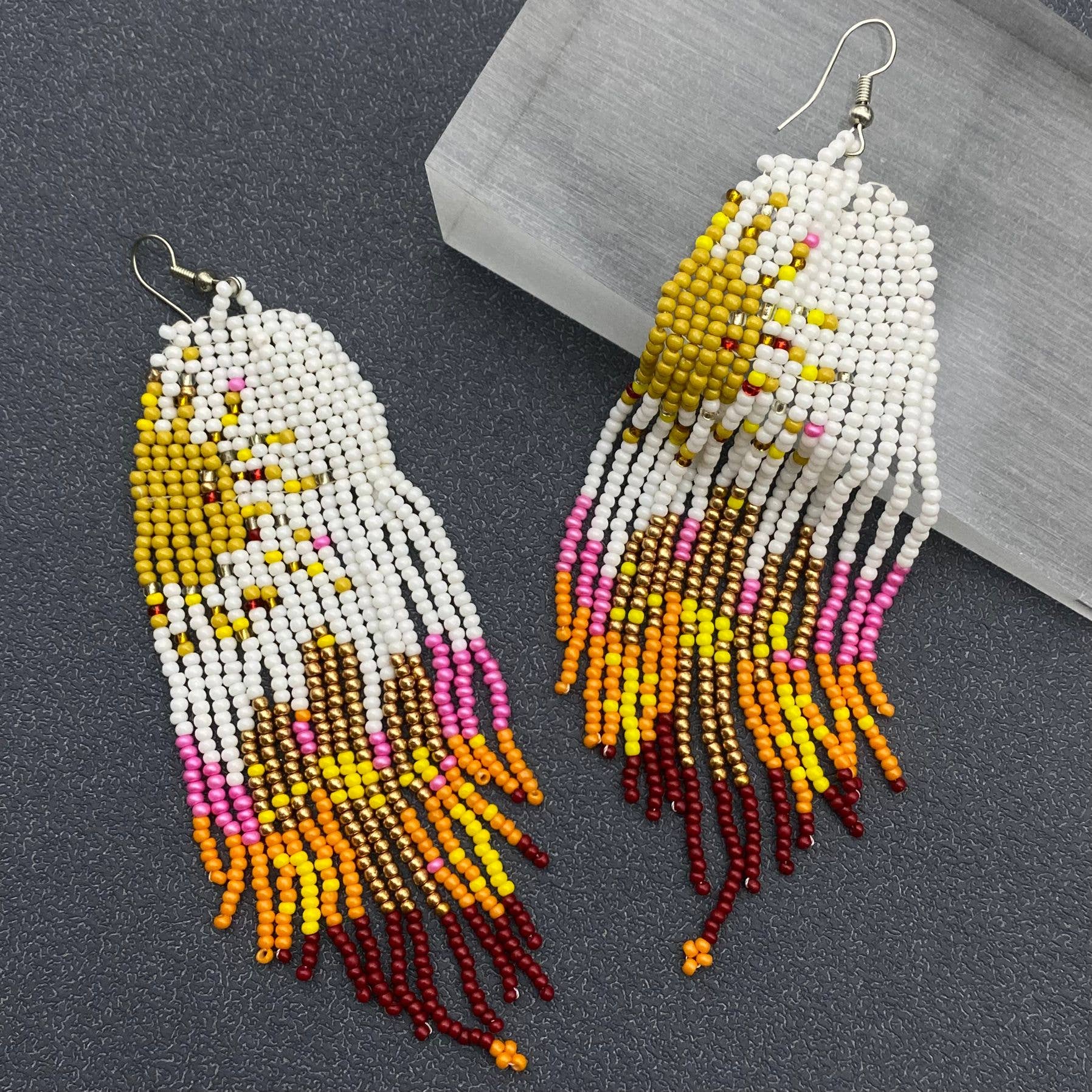 Hand-woven Sun Fringe Earrings by Mio Queena featuring intricate sun-shaped design and delicate fringe details.