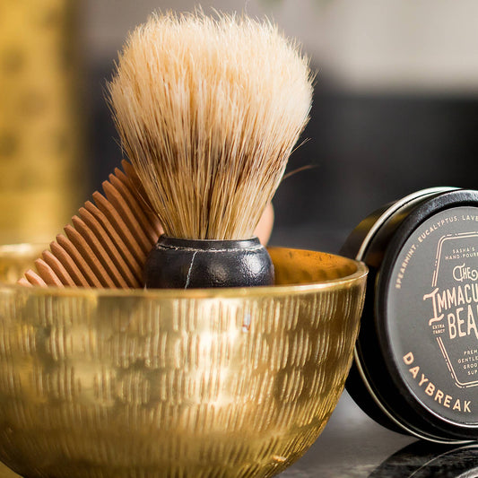 The Immaculate Beard shaving brush with wooden handle and soft bristles for a smooth shaving experience.