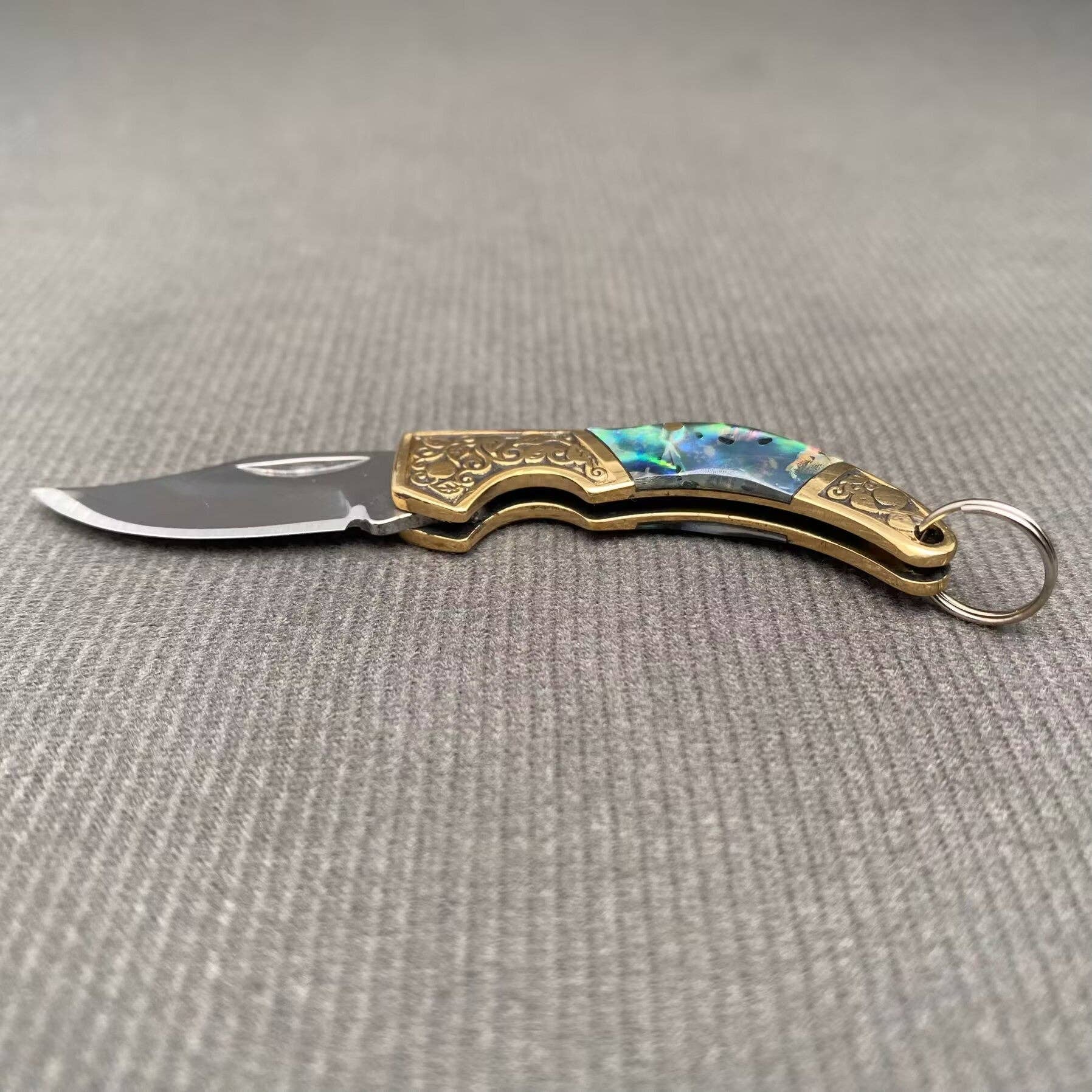 Tiny knife with shell inlay by Mio Queena, featuring a sleek blade and intricate shell design on the handle, ideal for collection or craft use.