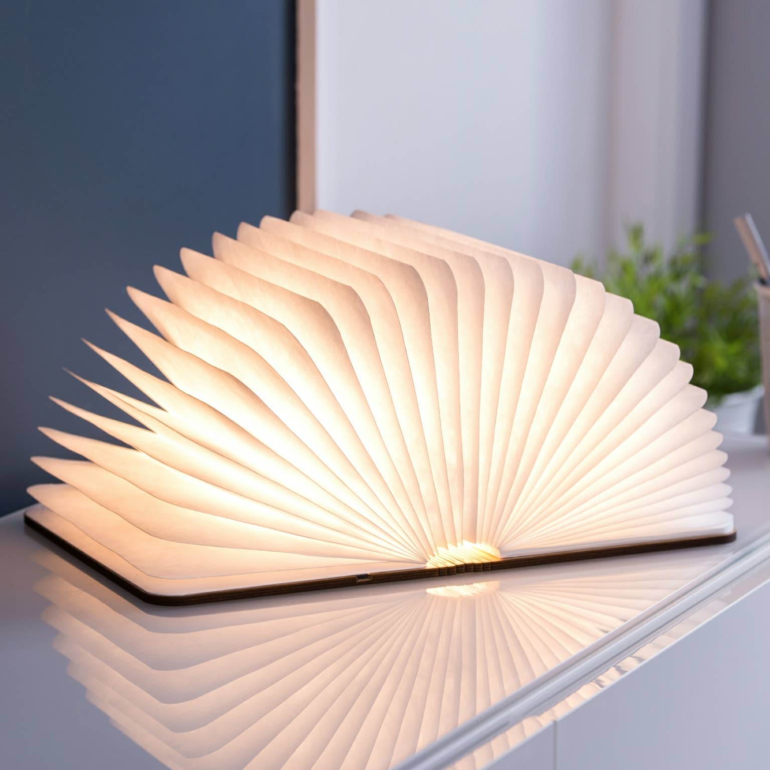 Natural wood smart book light by Gingko Design, featuring a sleek, compact lamp with a wooden finish, perfect for reading.
