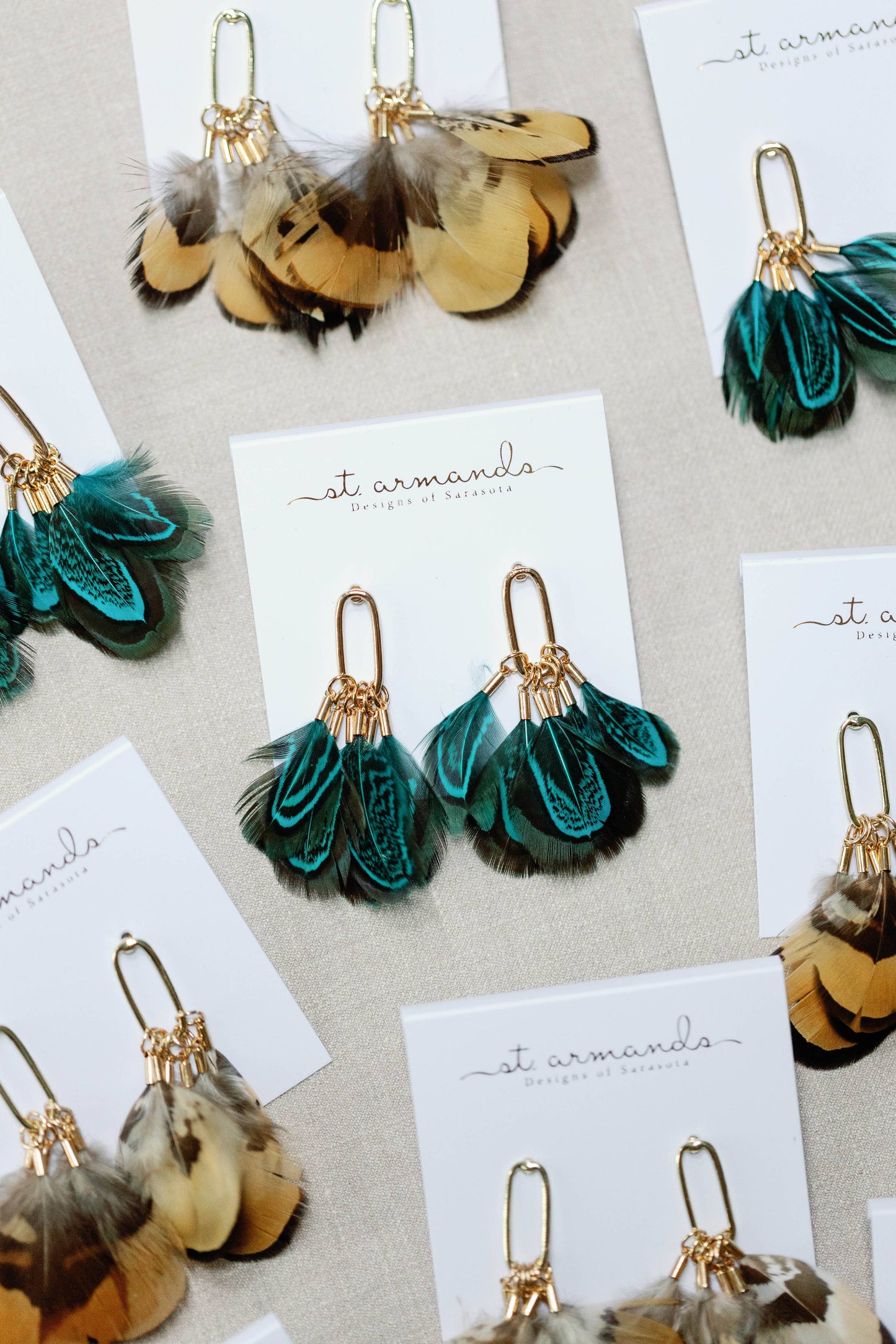 Peacock feather statement tassel earrings with vibrant feathers and gold accents, designed by St Armands Designs of Sarasota.