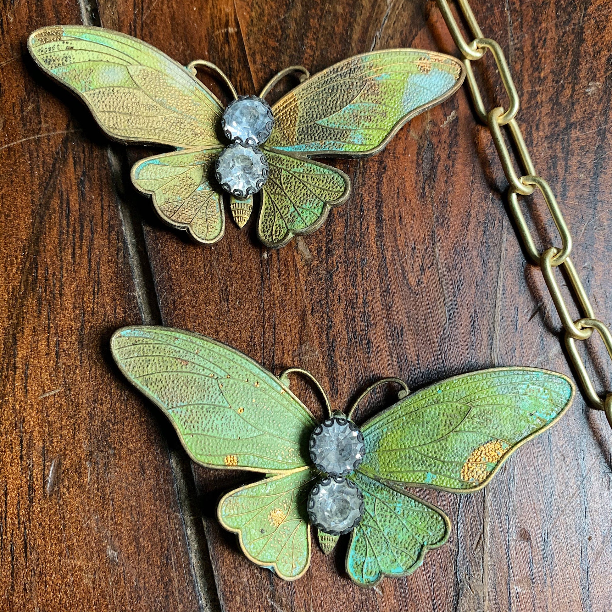 Chasing Cherubs Flutter necklace featuring a delicate chain and pendant with intricate design, displayed on a neutral background.