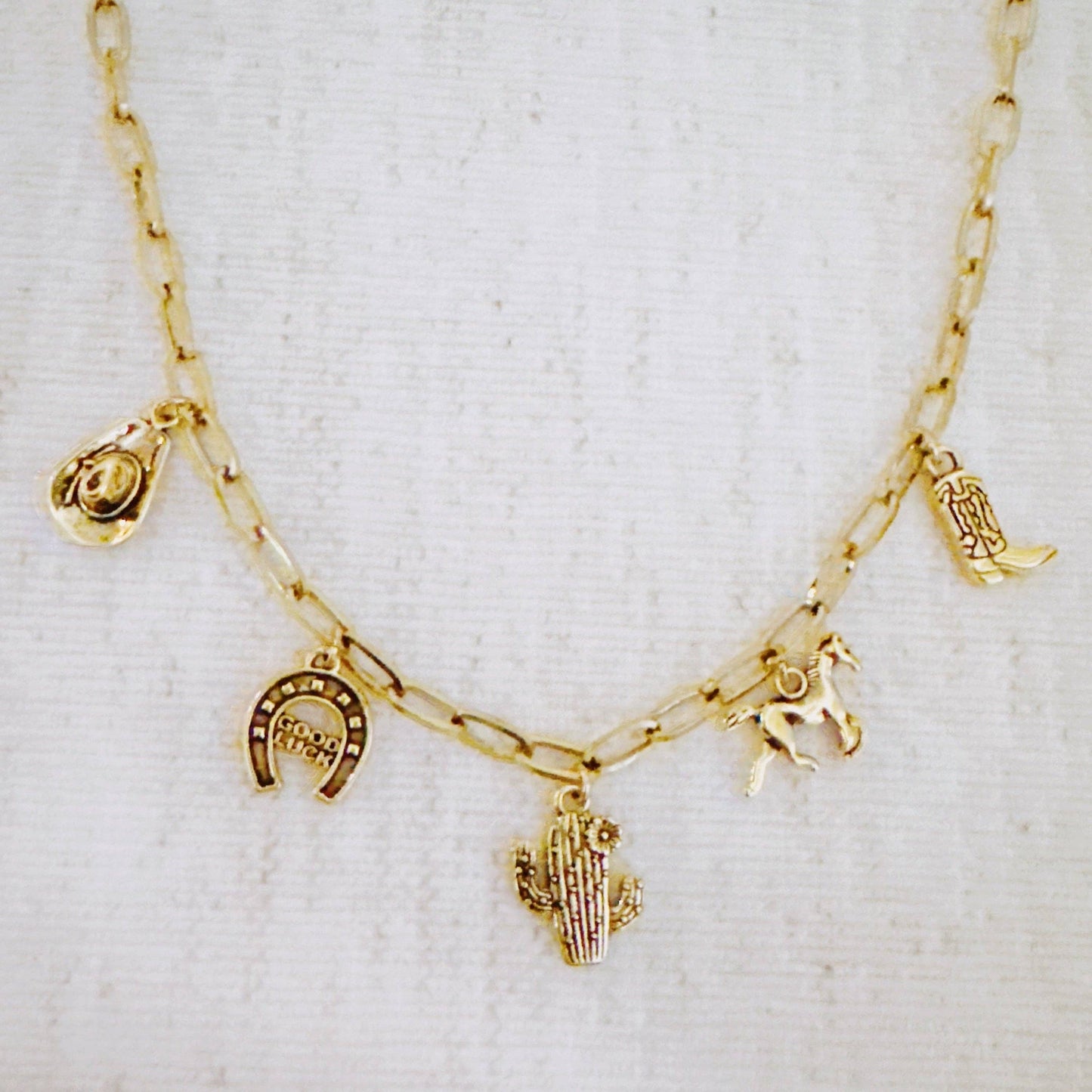 Western cowgirl charm necklace featuring cactus, horseshoe, and boot pendants by Ellison+Young, showcasing detailed jewelry design.