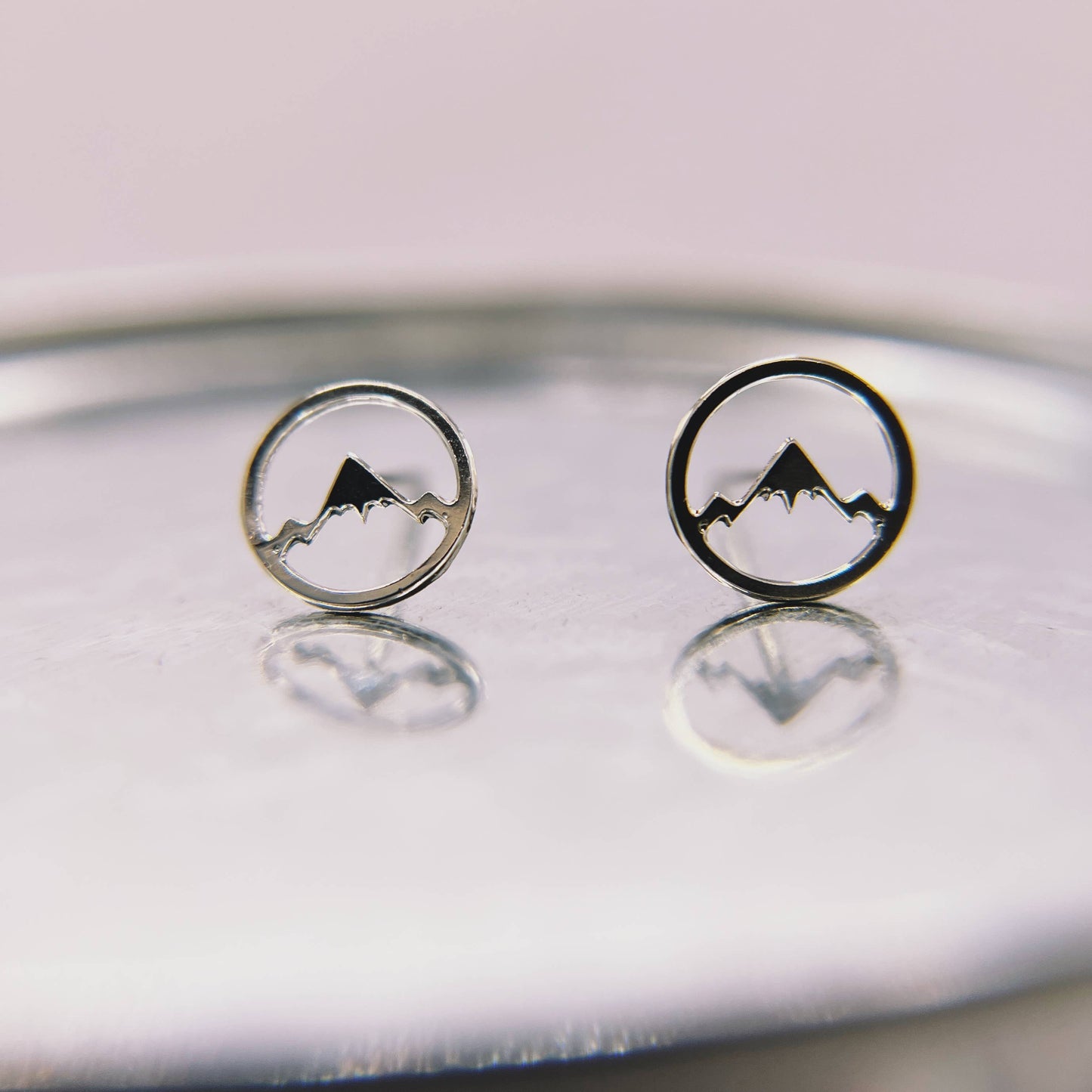 Mountainscape stud earrings by Made of Mountains featuring detailed mountain design in silver-tone metal.