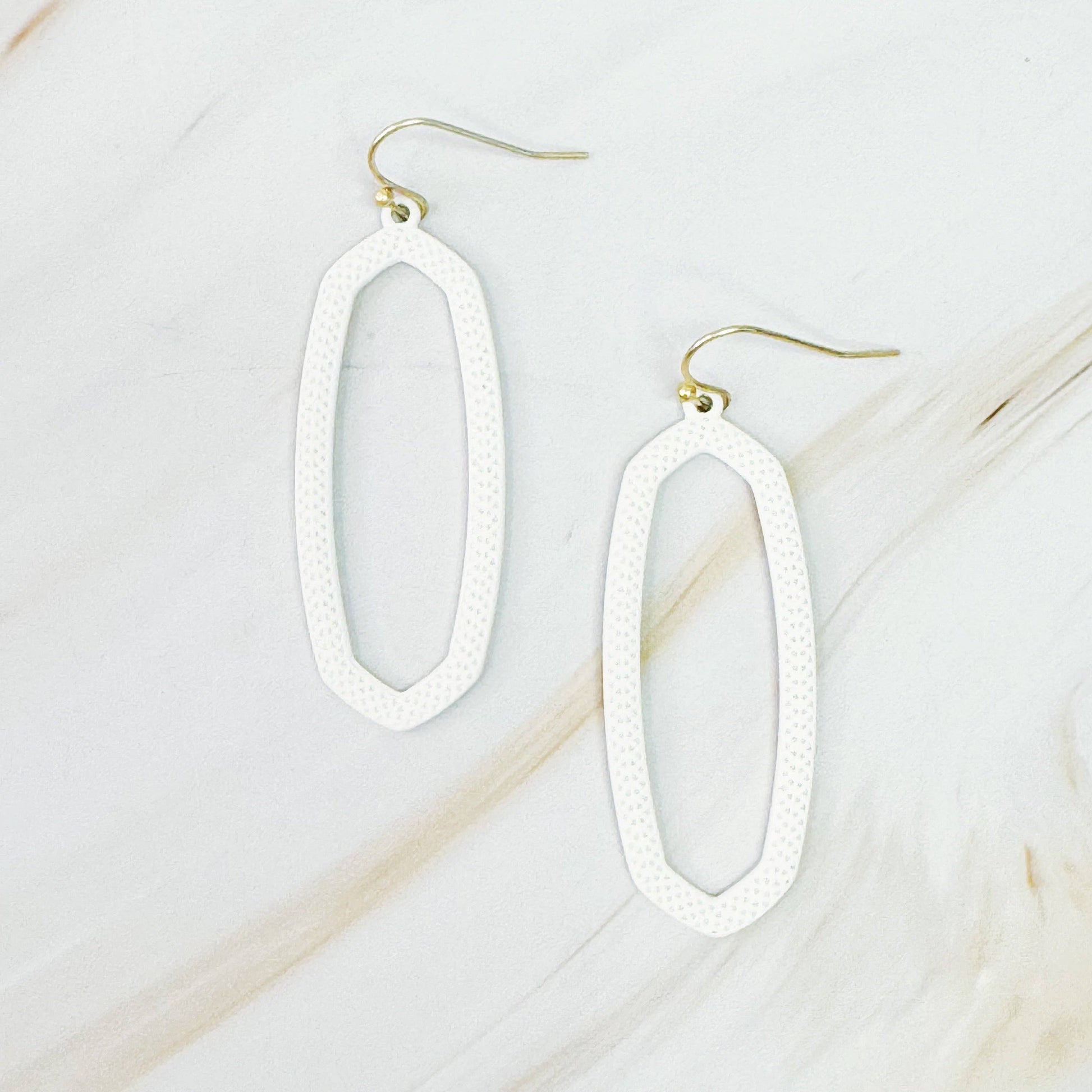 Ellison+Young Shape Of Game earrings featuring geometric, abstract design in silver, hanging from classic earring hooks.
