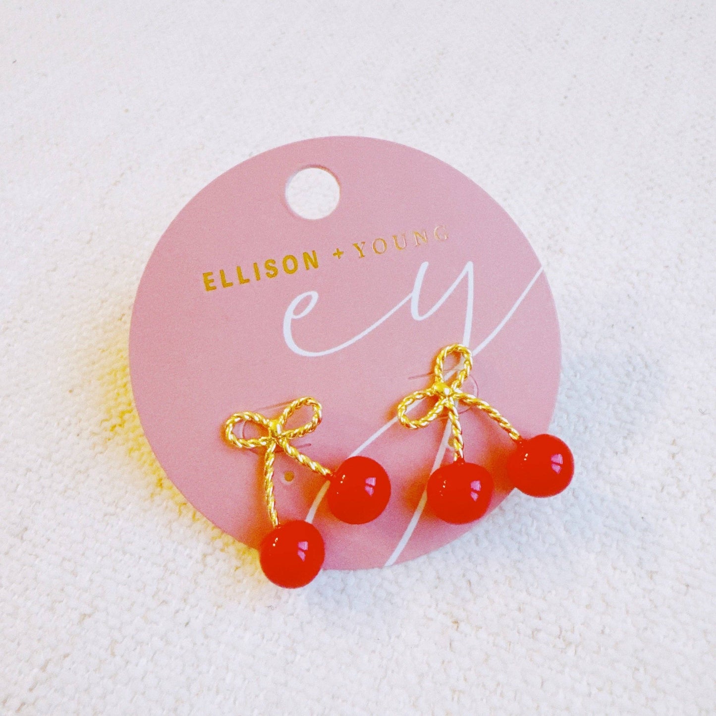 Ellison+Young bow and cherry earrings with gold-tone details, featuring delicate cherry charms and bow accents.