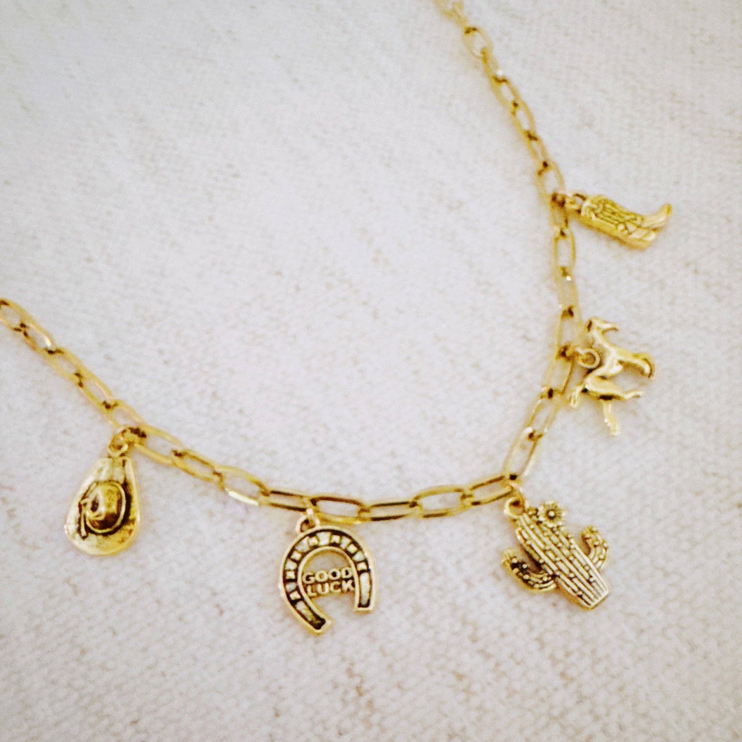 Western Cowgirl Charm Necklace by Ellison+Young featuring cactus, horseshoe, and boot charms on a necklace chain.