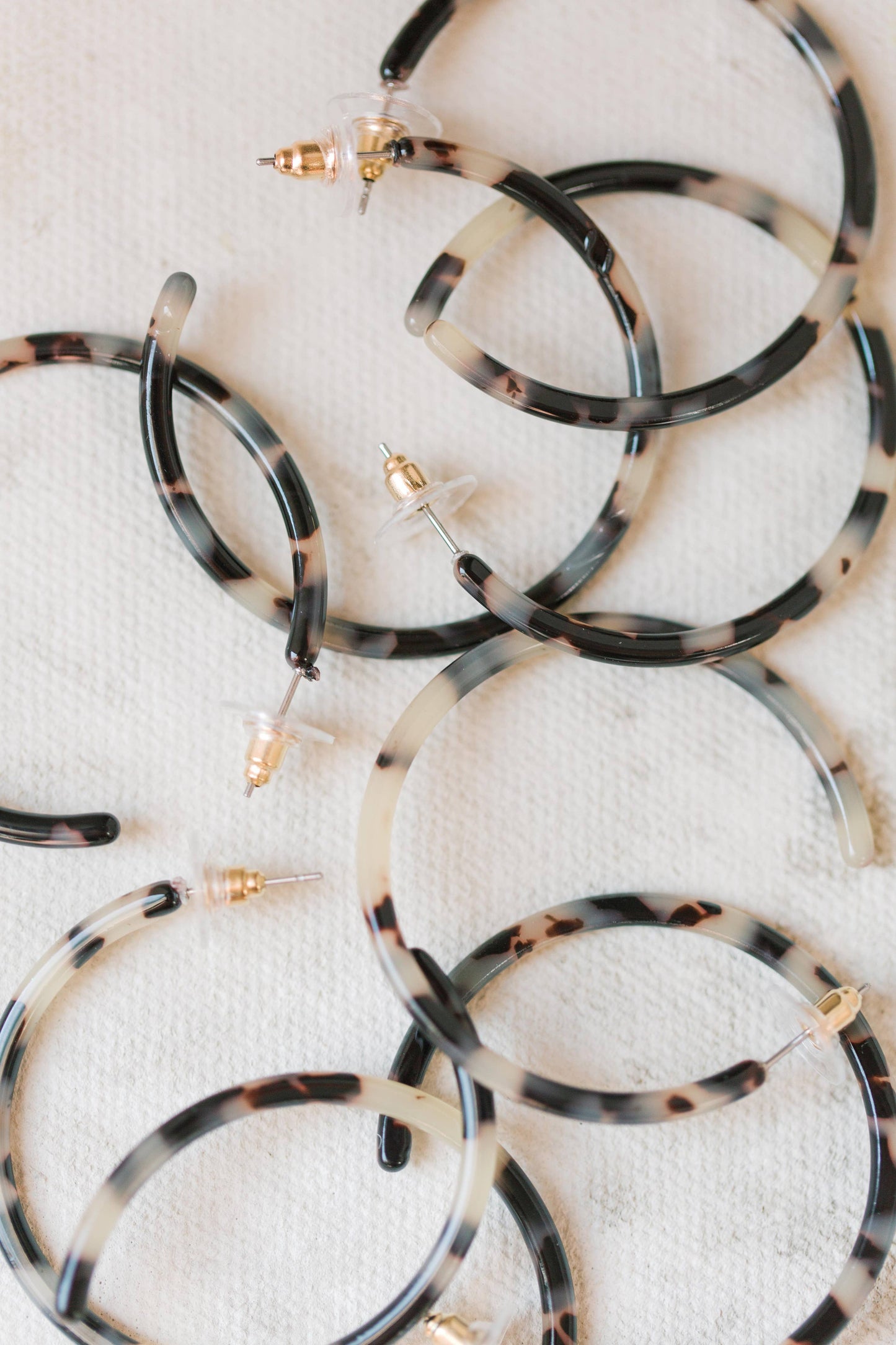 Gold-tone skinny blonde tortoise hoop earrings with a sleek, minimalist design from St Armands Designs of Sarasota.