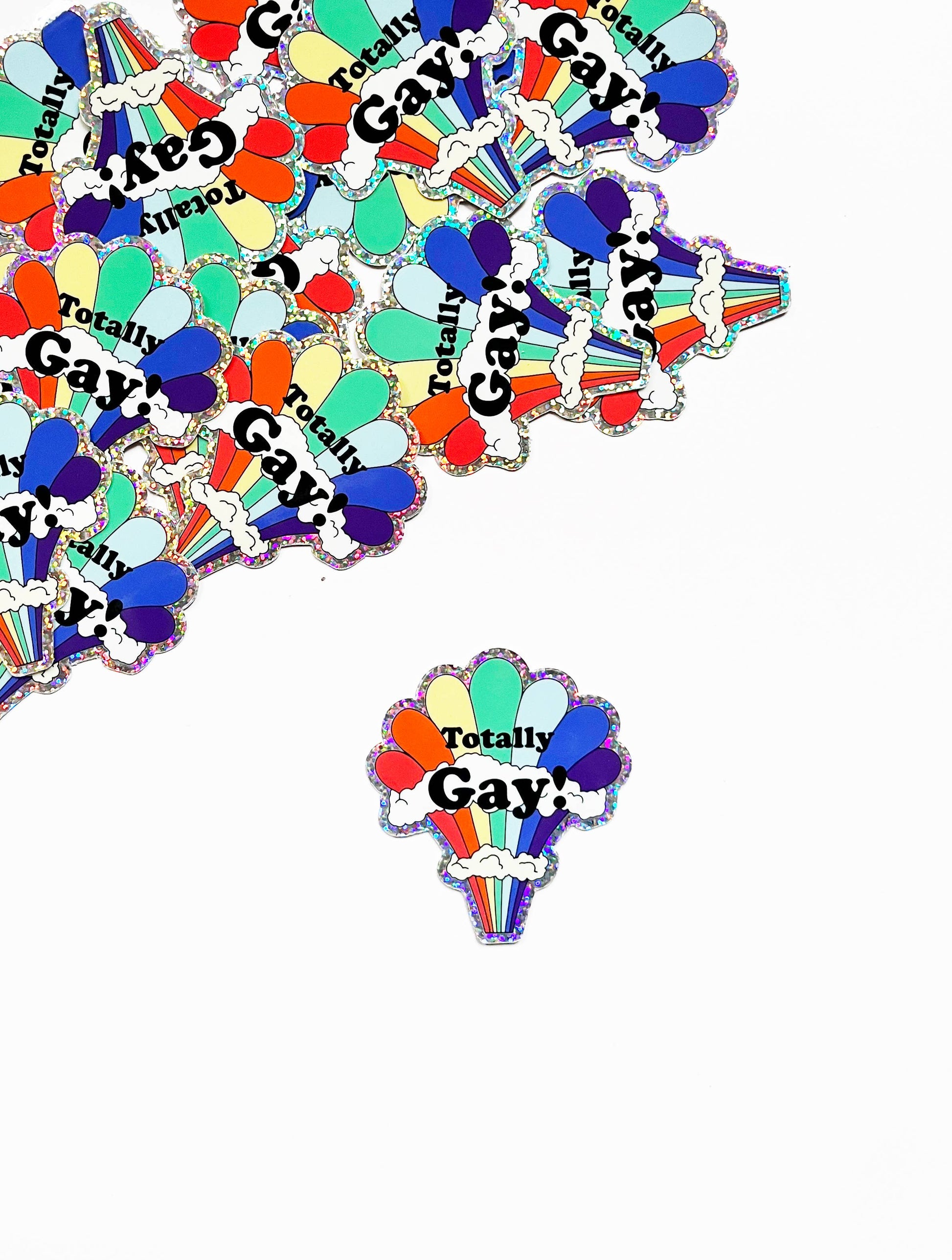 Colorful rainbow glitter sticker featuring the Totally Gay design from The Coin Laundry, perfect for decorating or expressing pride.