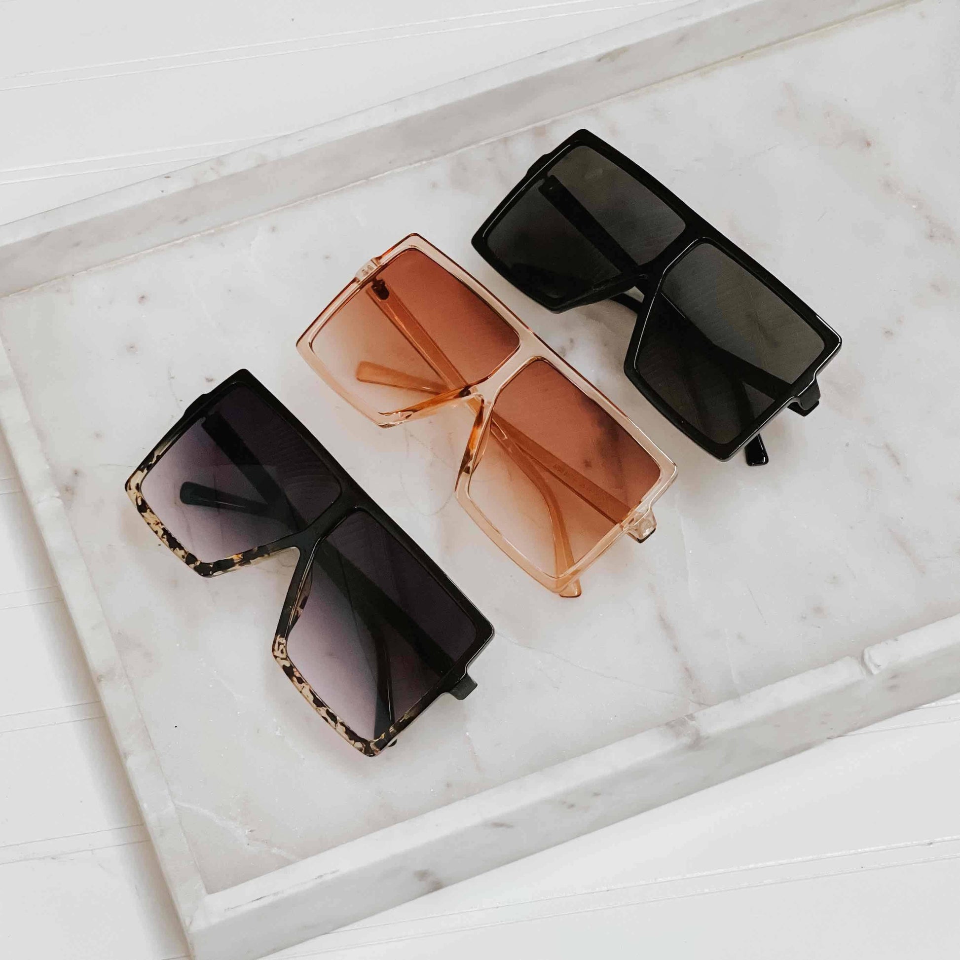 Pretty Simple Beverly oversized sunglasses with dark tinted lenses and thick black frames on a white background