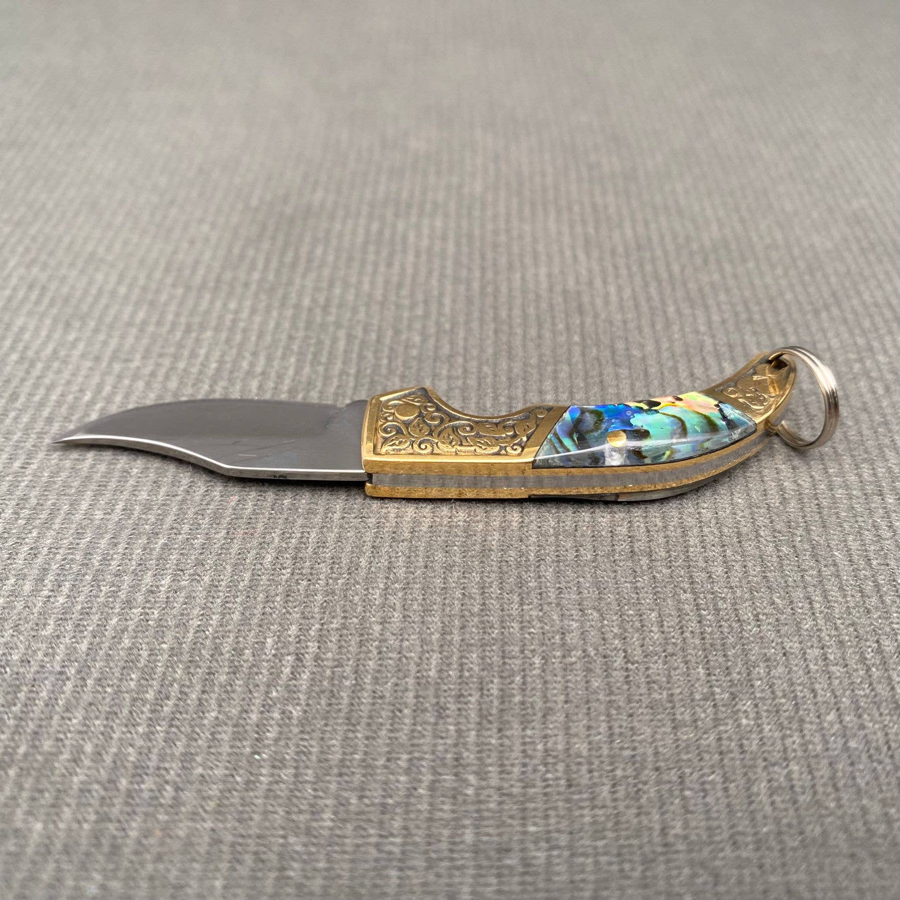 Close-up of Mio Queena Shell Inlaid Tiny Knife showcasing its detailed shell inlay and compact knife design.