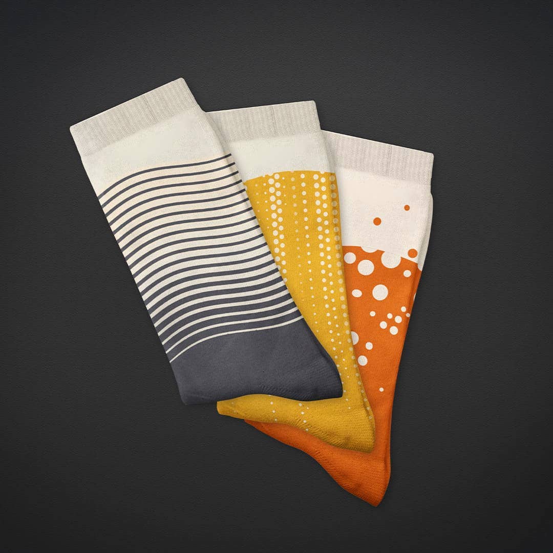 Pair of Craft Beer Socks by SUCK UK Ltd featuring colorful beer mug and hop patterns on comfortable socks.