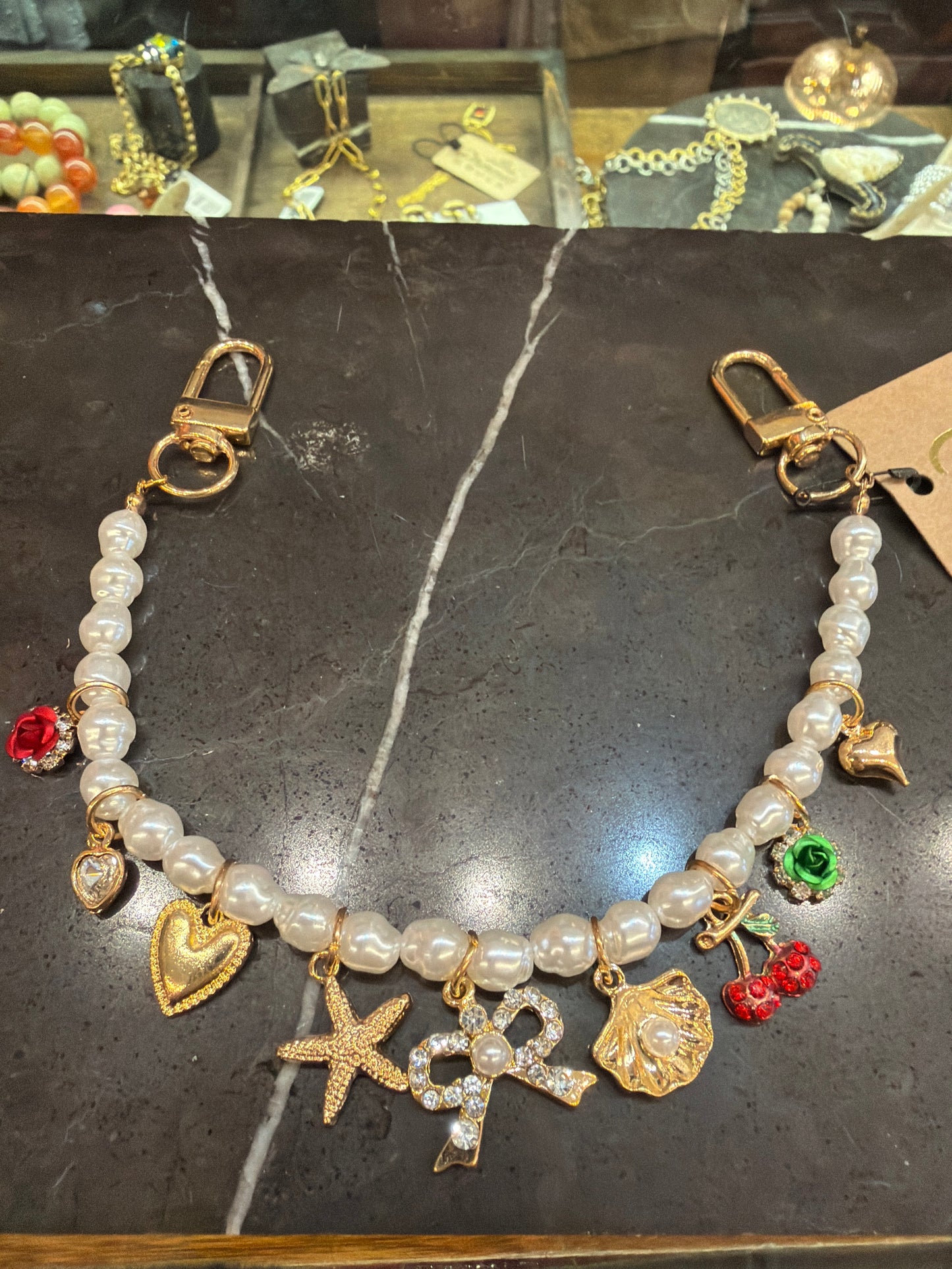Joia bag chain charm attached to a handbag, showcasing a stylish accessory for enhancing purse decor.