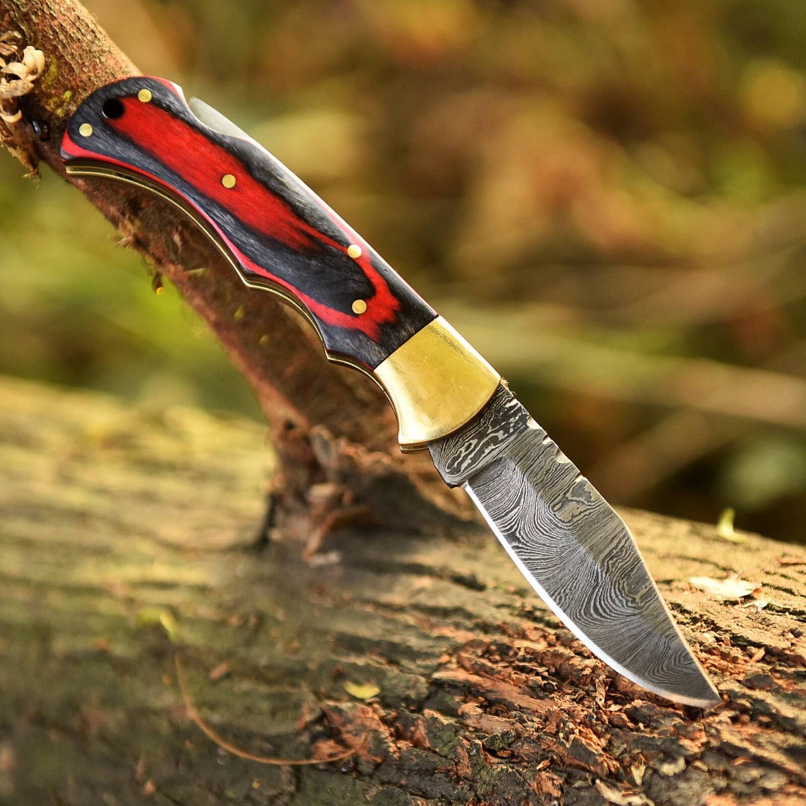 Handmade Damascus red and black wood folding knife by Liconte LLC, featuring a detailed blade and wooden handle.