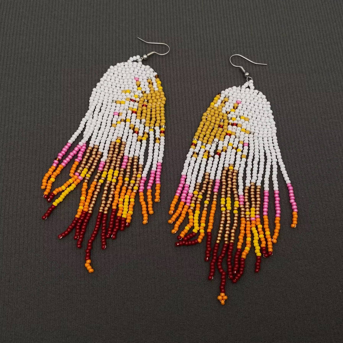 Hand-woven Sun Fringe Earrings by Mio Queena featuring intricate sun-inspired woven designs and dangling fringe details.
