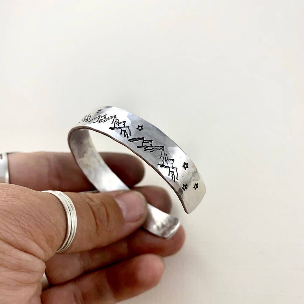 Handmade Mountain High cuff bracelet by Fluff Hardware featuring a rugged mountain design on silver-toned metal.