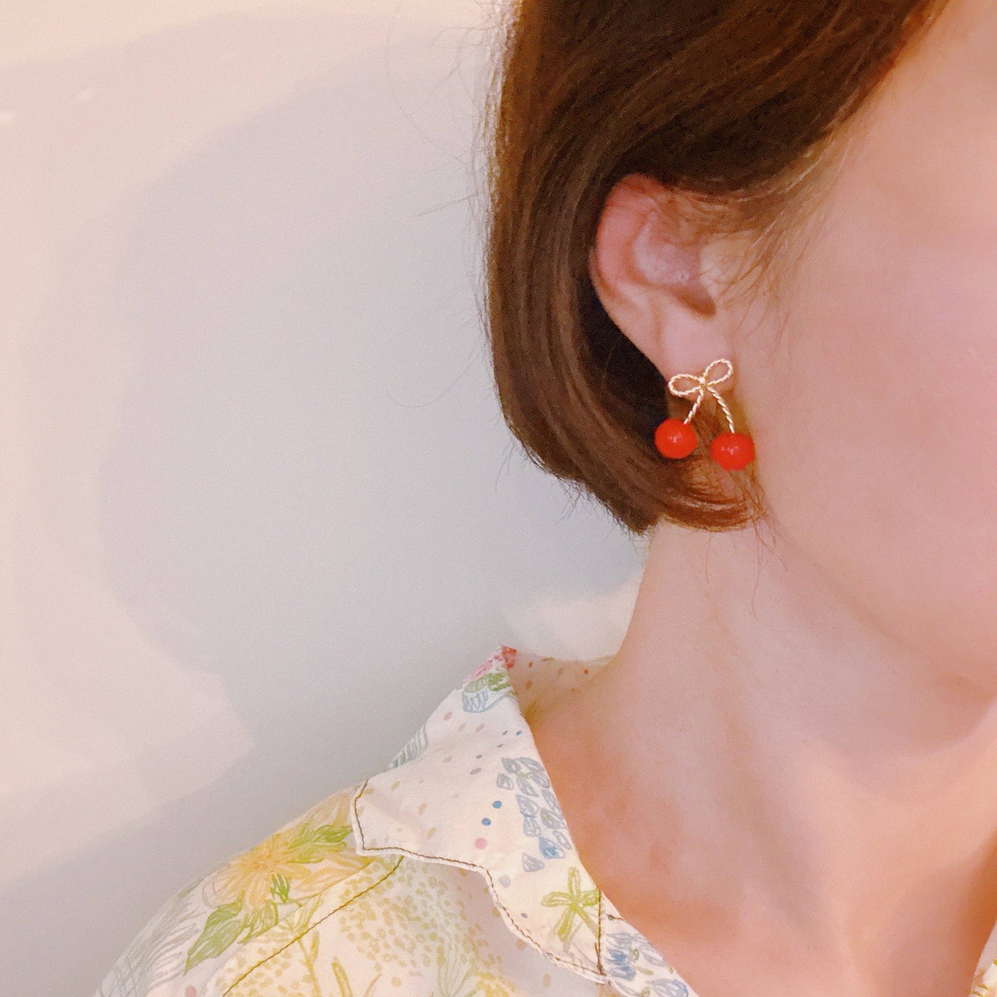 Ellison+Young bow and cherry earrings featuring delicate cherry charm and bow design on silver hooks.