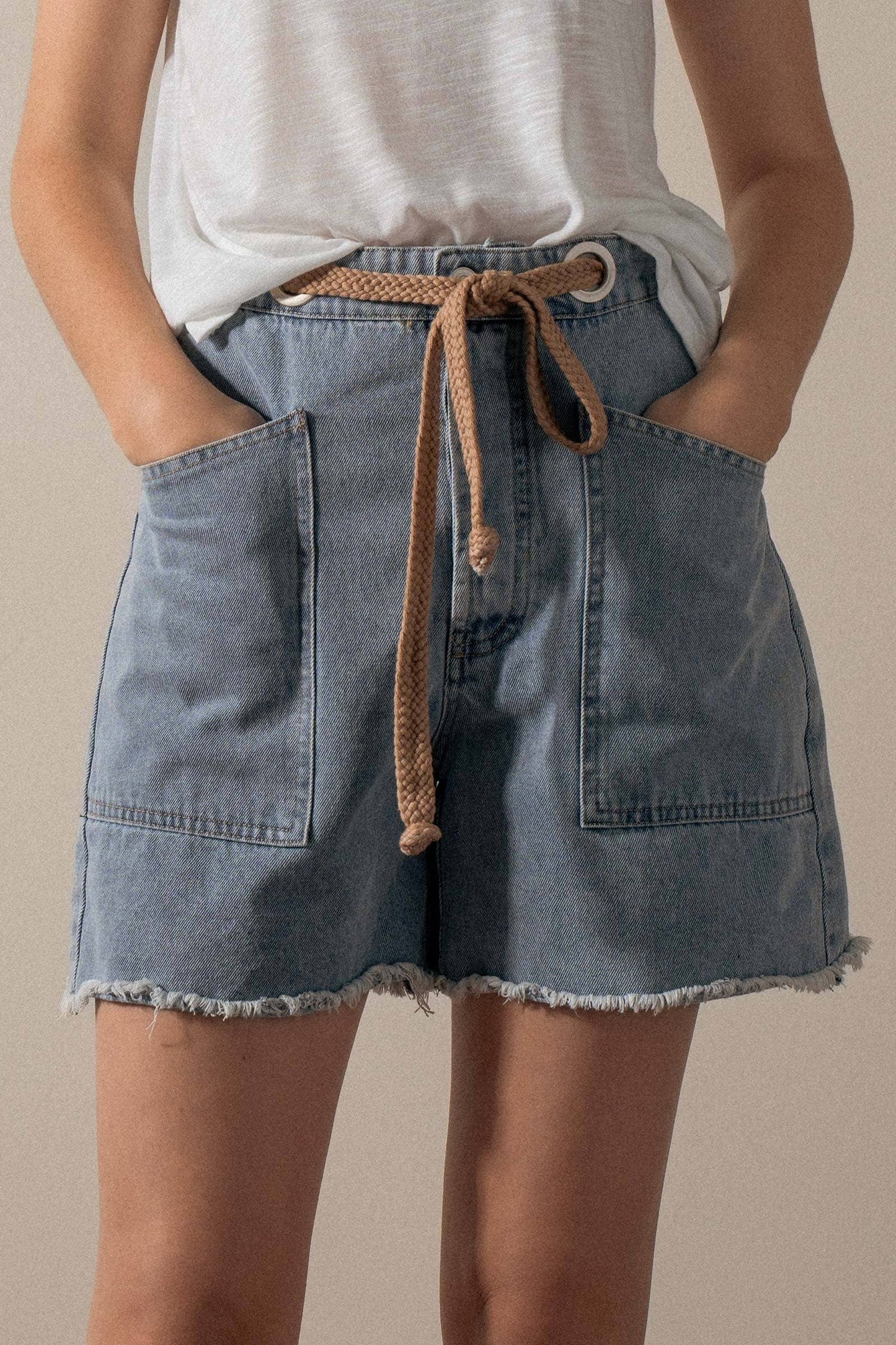 High-waisted frayed hem denim shorts by Urban Daizy, showcasing distressed edges and classic blue denim fabric.