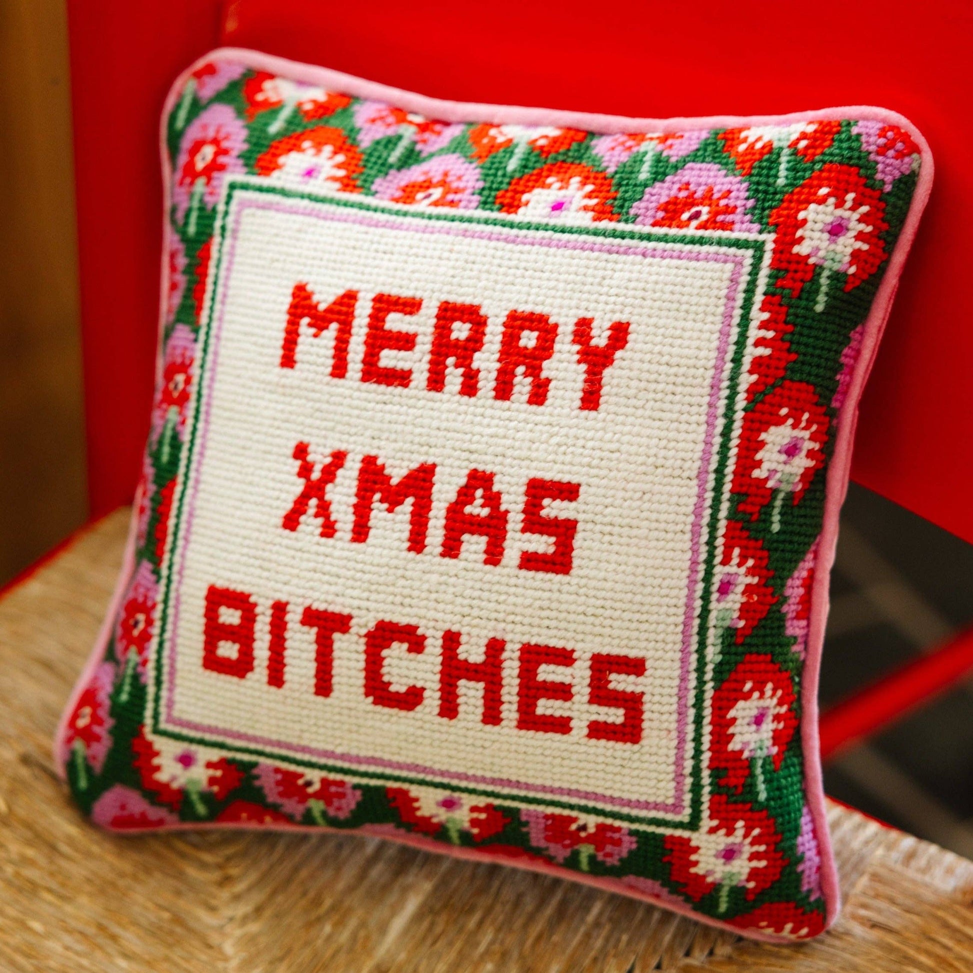 Furbish Studio Merry Xmas Bitches needlepoint pillow with festive red and white design featuring holiday-themed text and patterns.