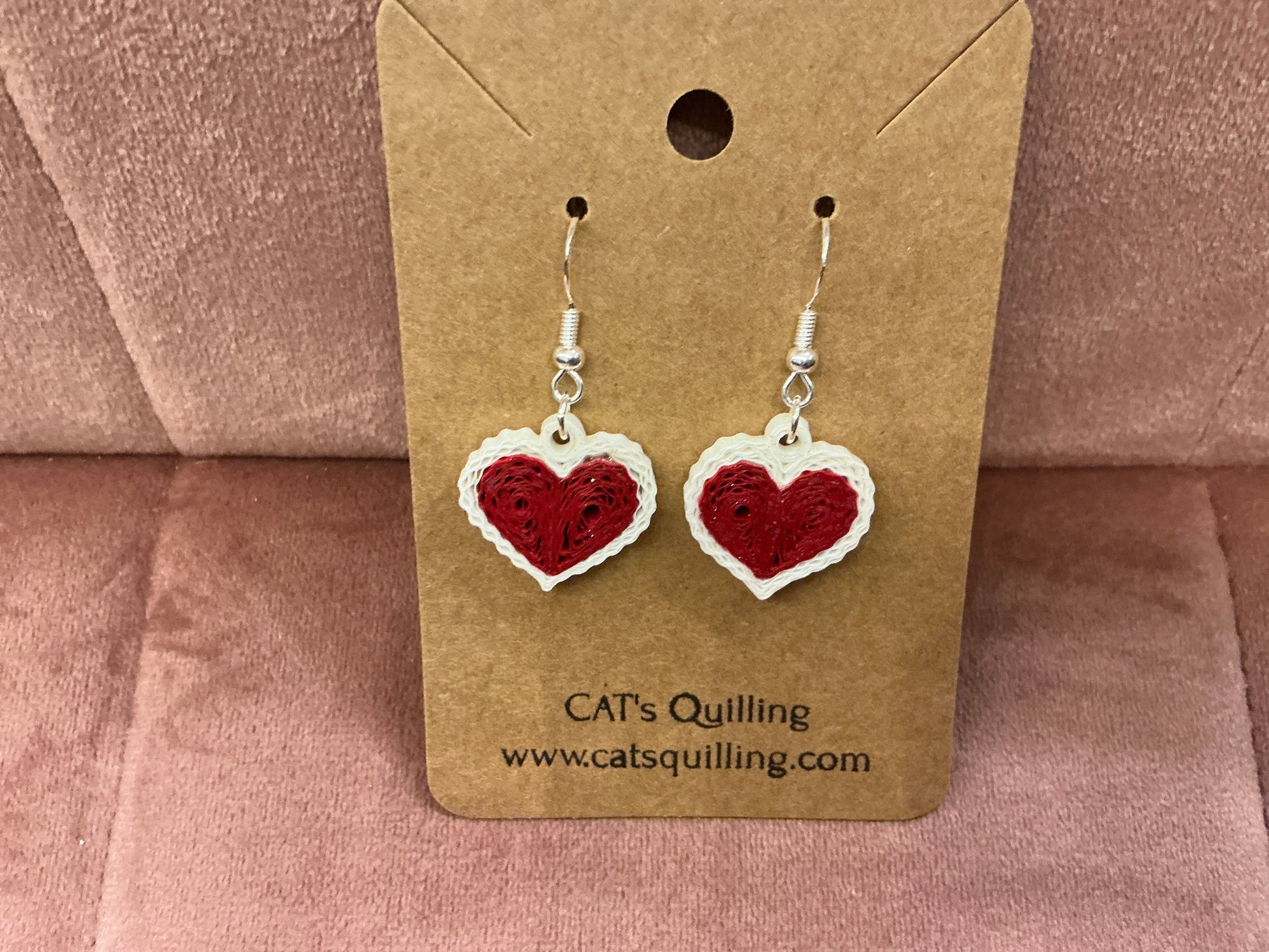 Colorful quilled heart earrings by Cat's Quilling featuring intricate paper coil designs and silver hooks for a charming look.