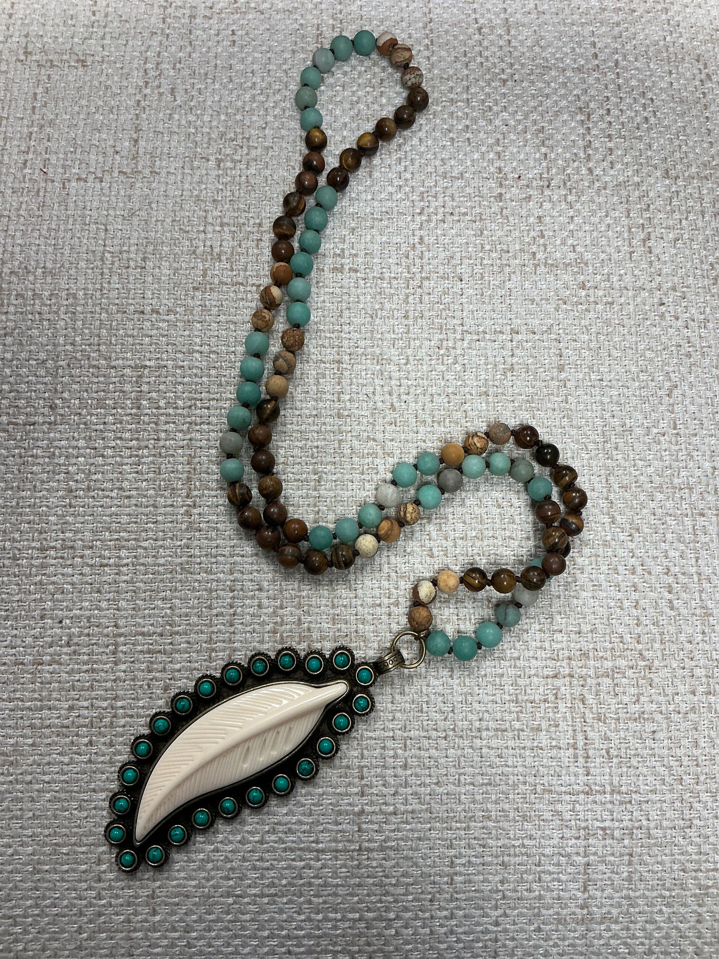 Beaded feather talisman necklace with colorful beads and feather pendant, crafted by American Unique Group.