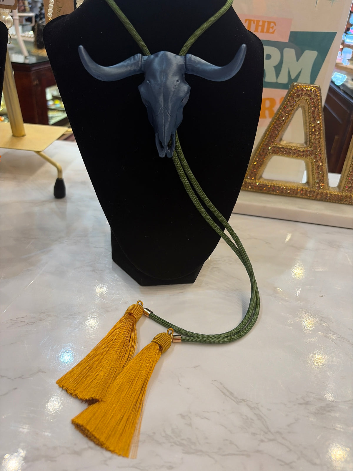 Rahya Bolo Necklace from Rahya Jewelry Design featuring a stylish bolo tie with decorative metal accents and adjustable cord.