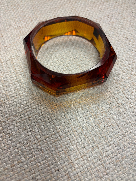 Amber Ice bangle bracelet by Queen Gypsy featuring a smooth amber-colored glass design on a silver-tone metal band.