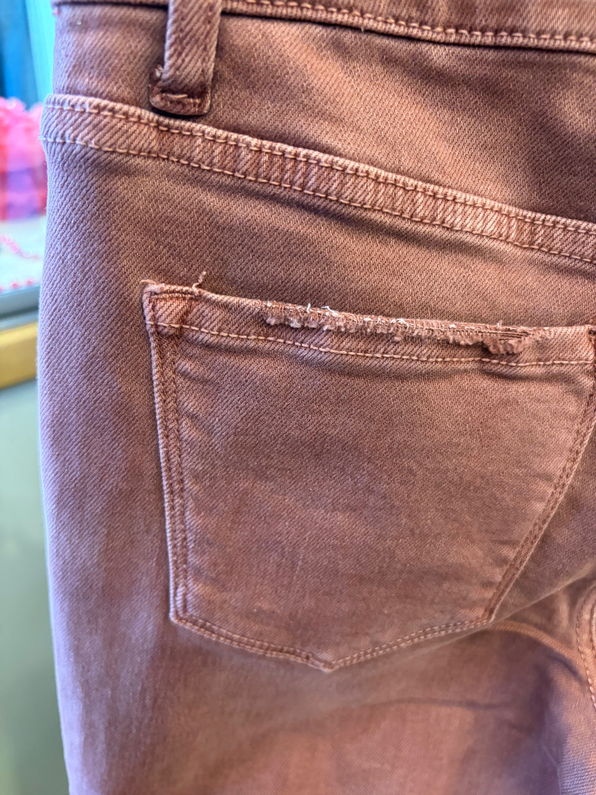 Vervet Wine Time jeans featuring a stylish denim design, shown hanging on a rack with a focus on the back pocket details.