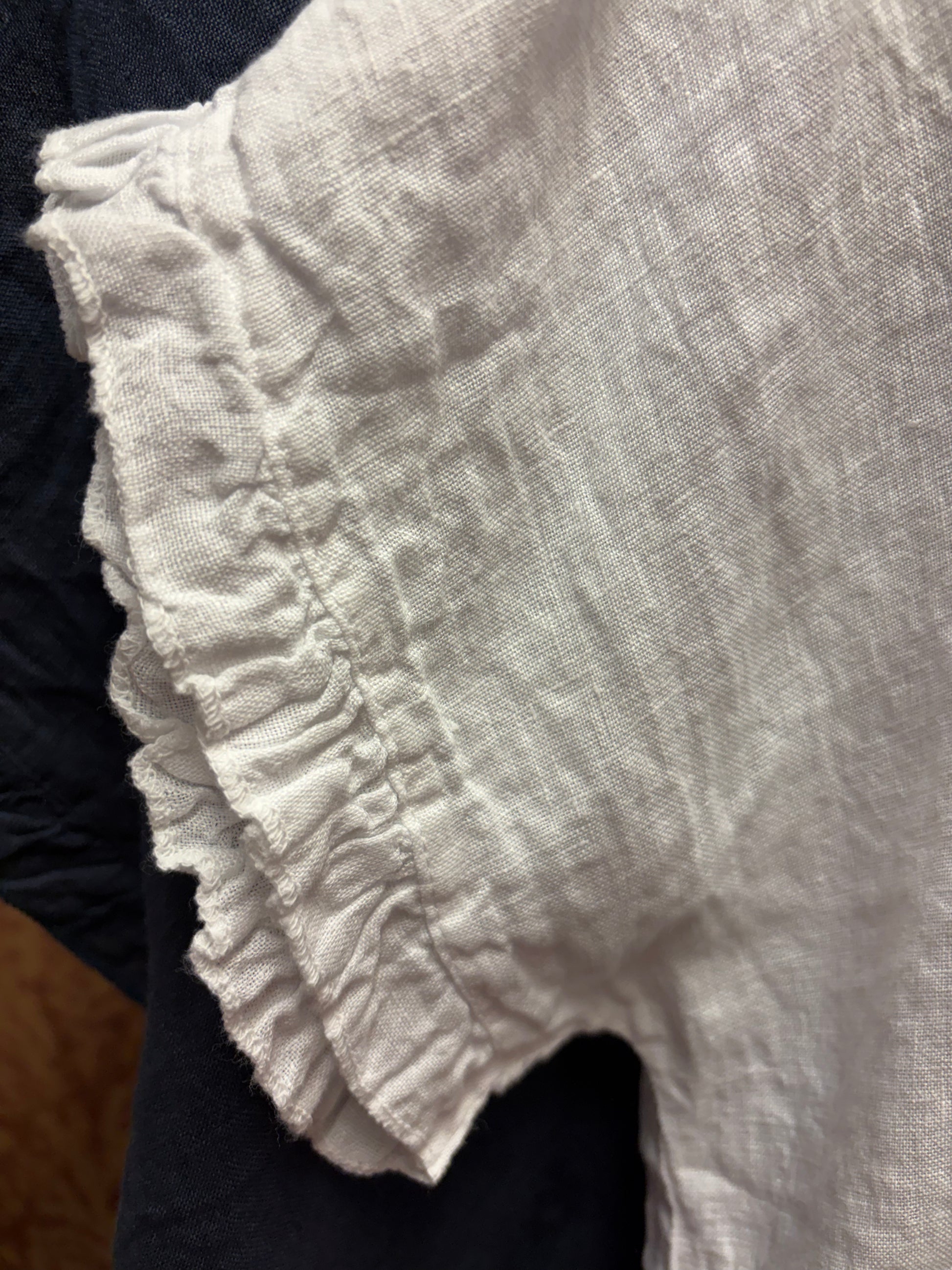 Camille & Co. ruffle linen top featuring a flowy design with ruffled sleeves and a lightweight, breezy fabric for warm weather.