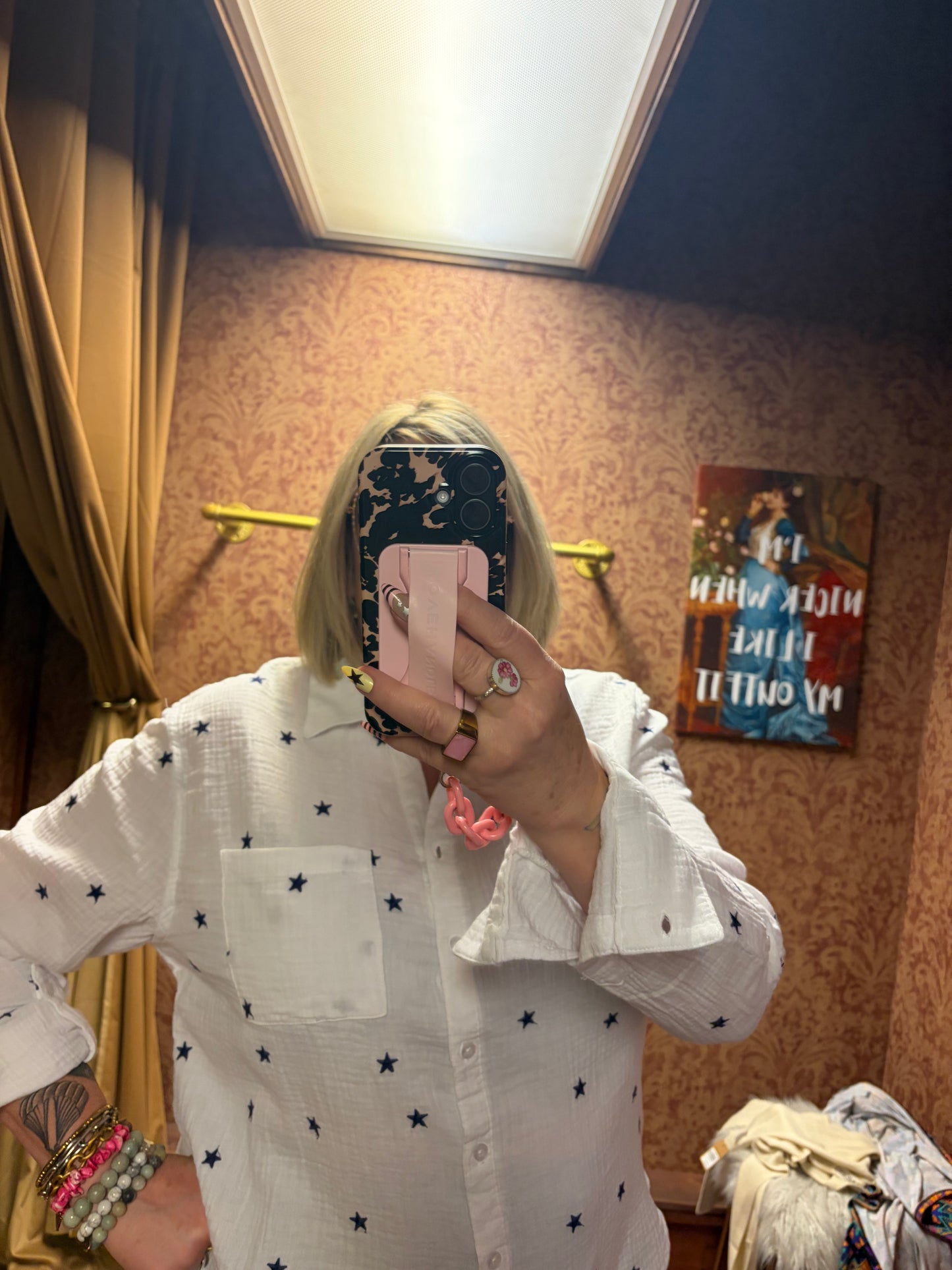 Camille & Co. Reach for the Stars blouse featuring a flowy fabric with star pattern and long sleeves, displayed on a hanger.