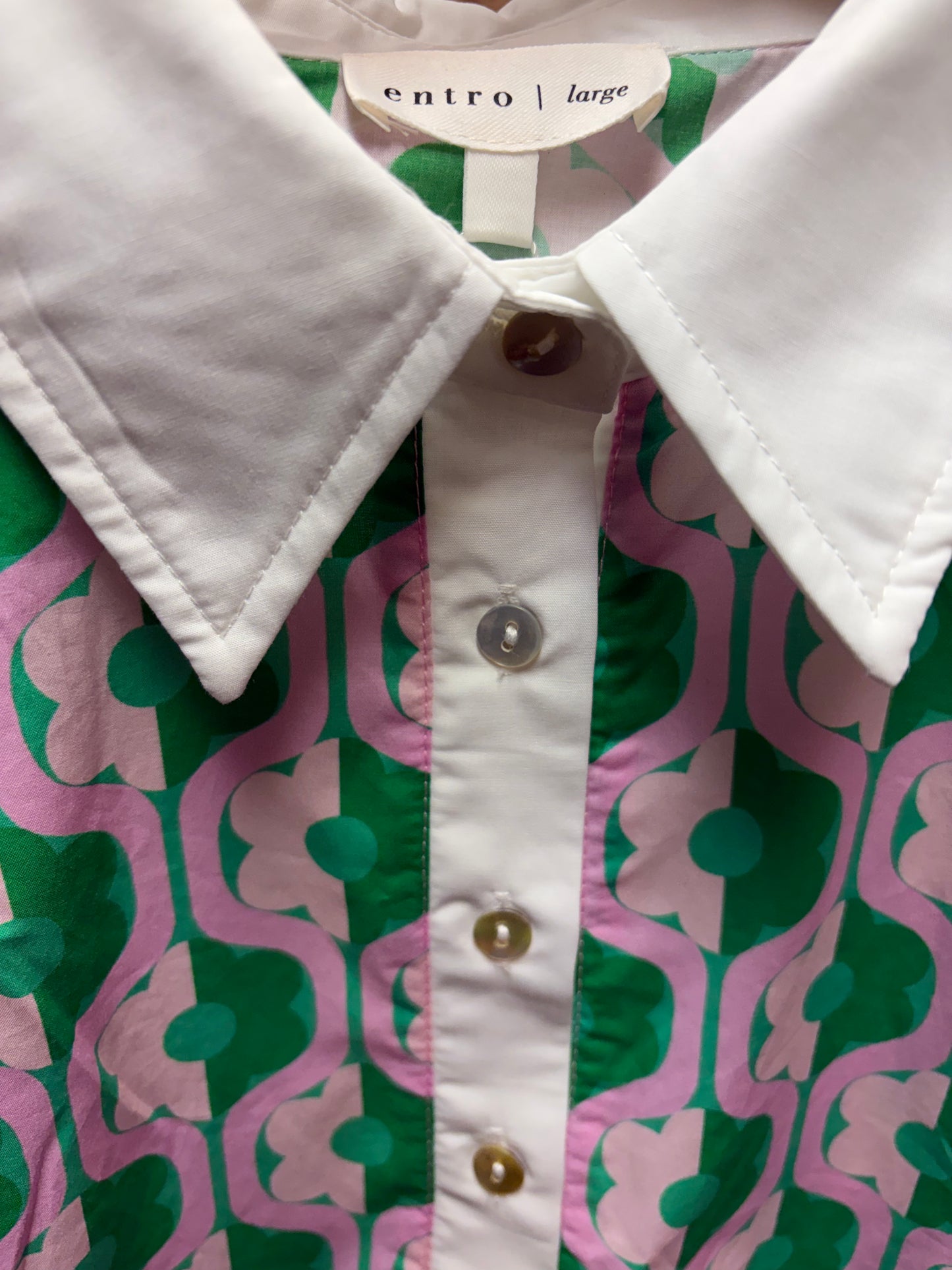 Entro Mod Floral Blouse featuring a vibrant floral pattern and lightweight fabric, displayed on a hanger.