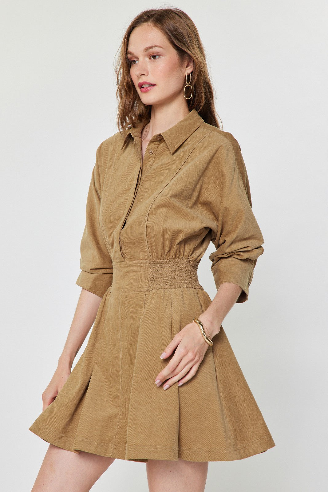 Current Air camel shirt collar mini dress hanging on a wooden hanger, showcasing its stylish design and fabric details.
