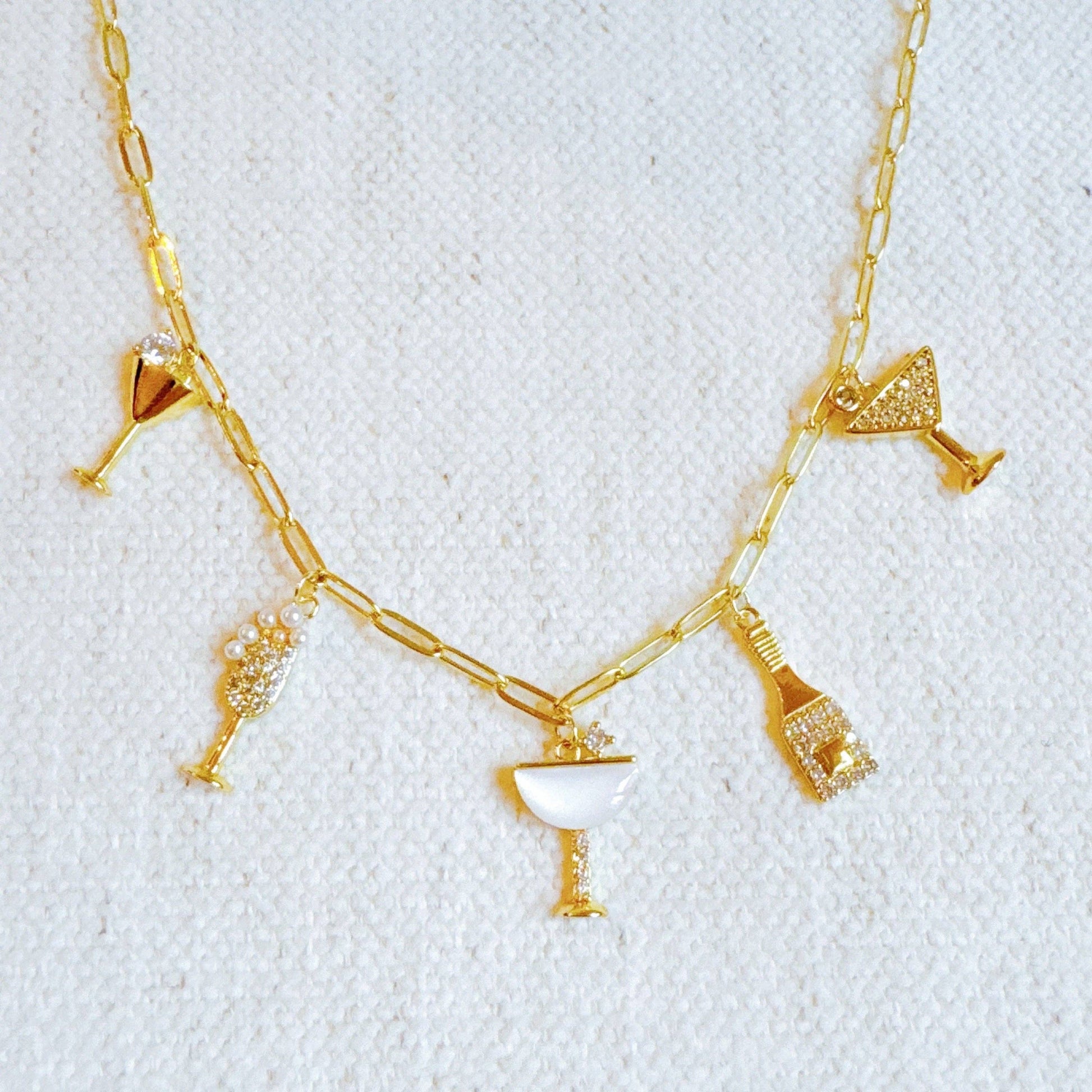 Ellison+Young Cheers To Happiness multi charm necklace with colorful charms on a silver chain, close-up view.