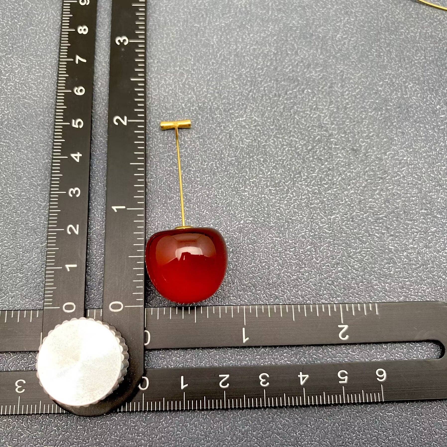 Cherry resin earrings by Mio Queena featuring vibrant red resin with a delicate earring hook design.