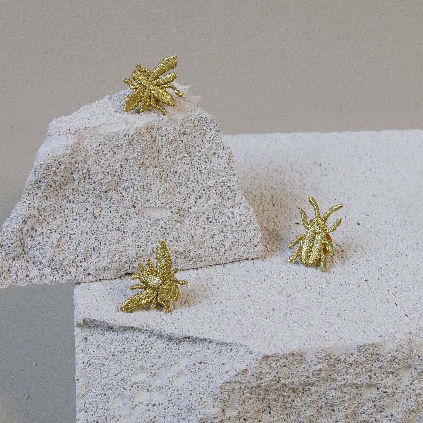 Golden embroidered bug pins featuring three tiny insect designs, perfect for plant lovers' decor or accessories.